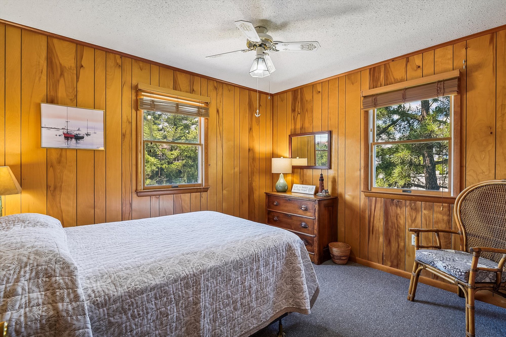 Wake up surrounded by warm wood paneling and natural light streaming through double windows. Your peaceful retreat features a cozy bed, vintage charm, and a quiet place to unwind after a day exploring.