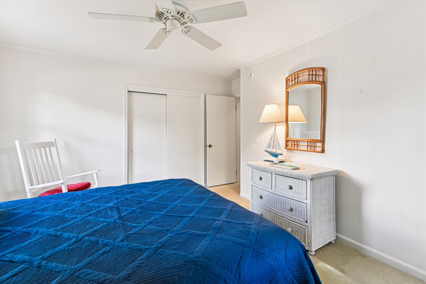 Rest peacefully in your coastal bedroom with nautical touches, wicker dresser, and ceiling fan for comfort.