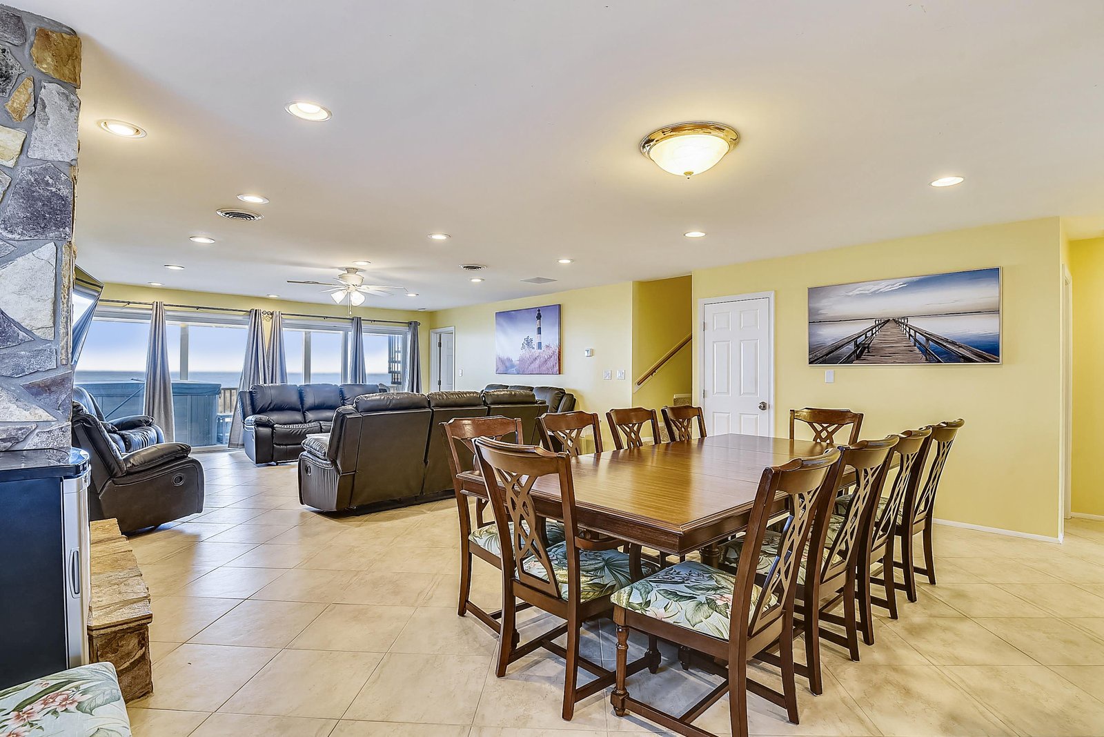 Gather everyone around the spacious dining table for laughter-filled meals, then unwind in the living area where ocean views stretch beyond the windows, inviting you to relax and soak in the coastal serenity.