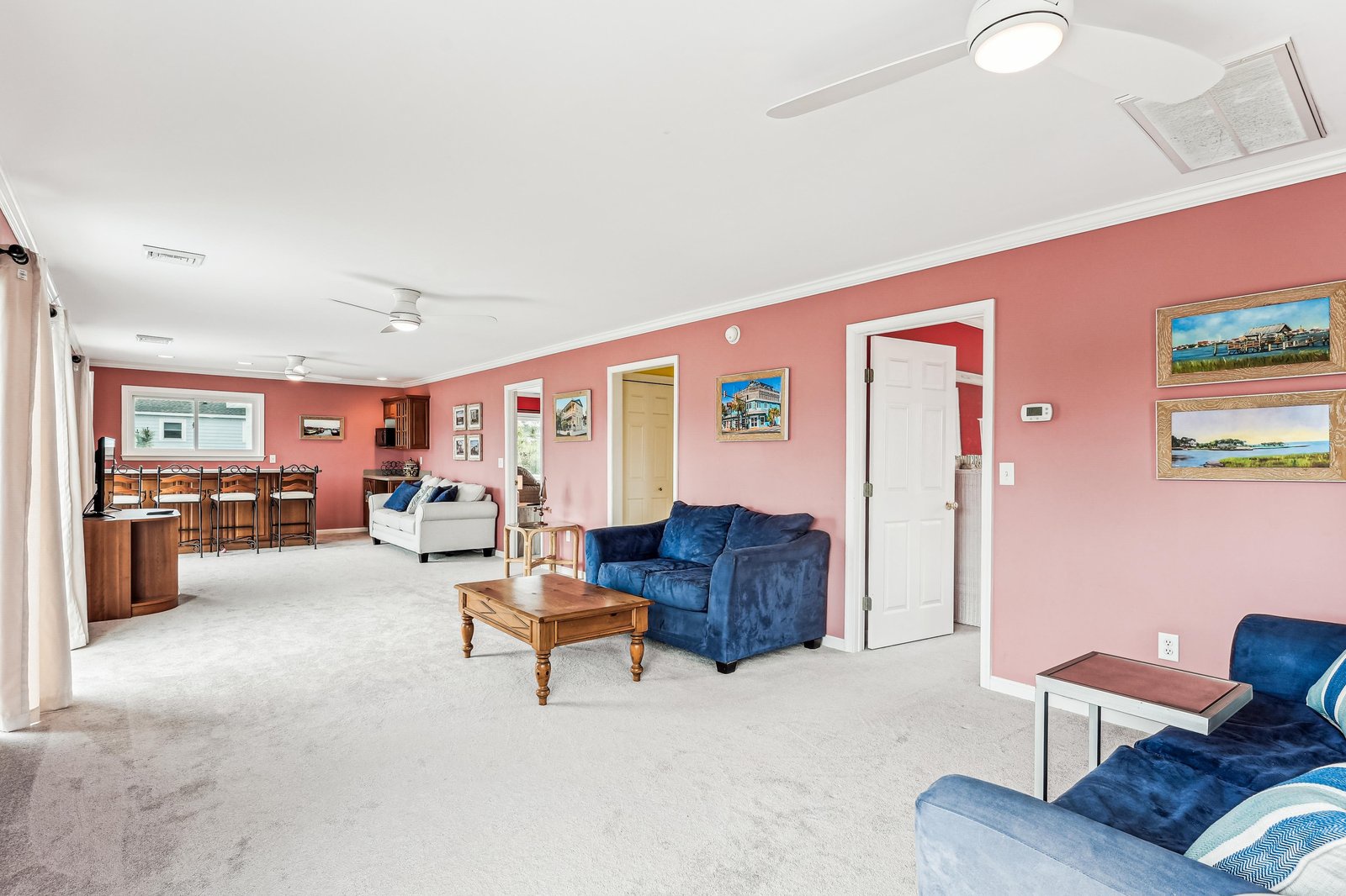 Sink into plush velvet sofas and enjoy your open-plan retreat. Warm coral walls and generous natural light create a welcoming space for relaxing after a day of exploring.