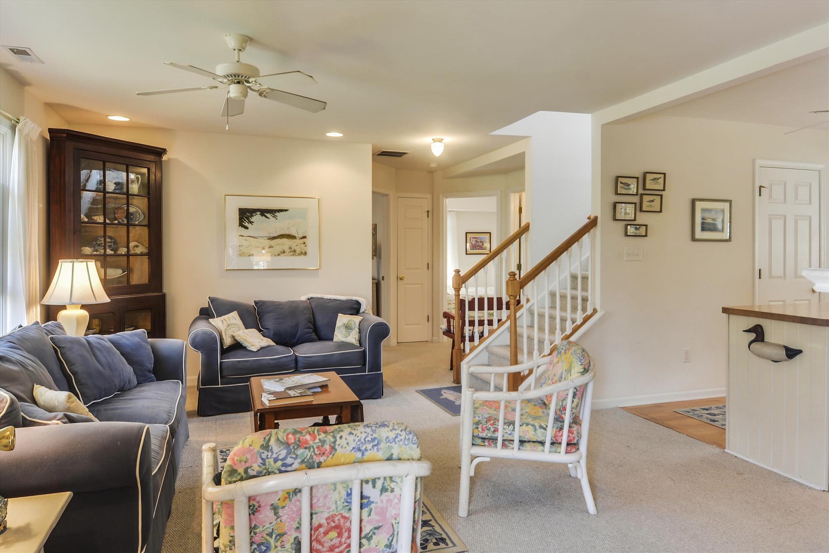 Settle into your cozy living space with plush navy sofas and coastal charm. The ceiling fan keeps you comfortable while you relax and plan your next adventure.