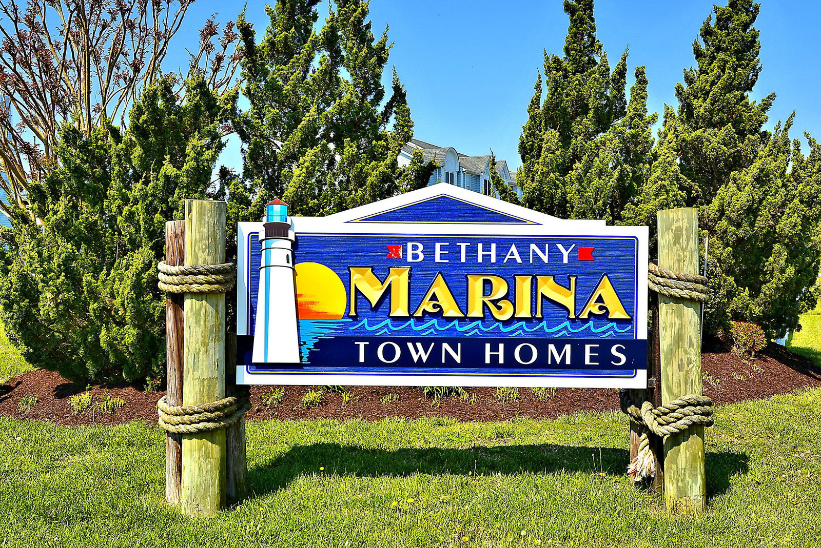 Bethany Marina Town Homes entrance marker with nautical-themed design featuring a lighthouse motif and vibrant colors, set in a landscaped community area.