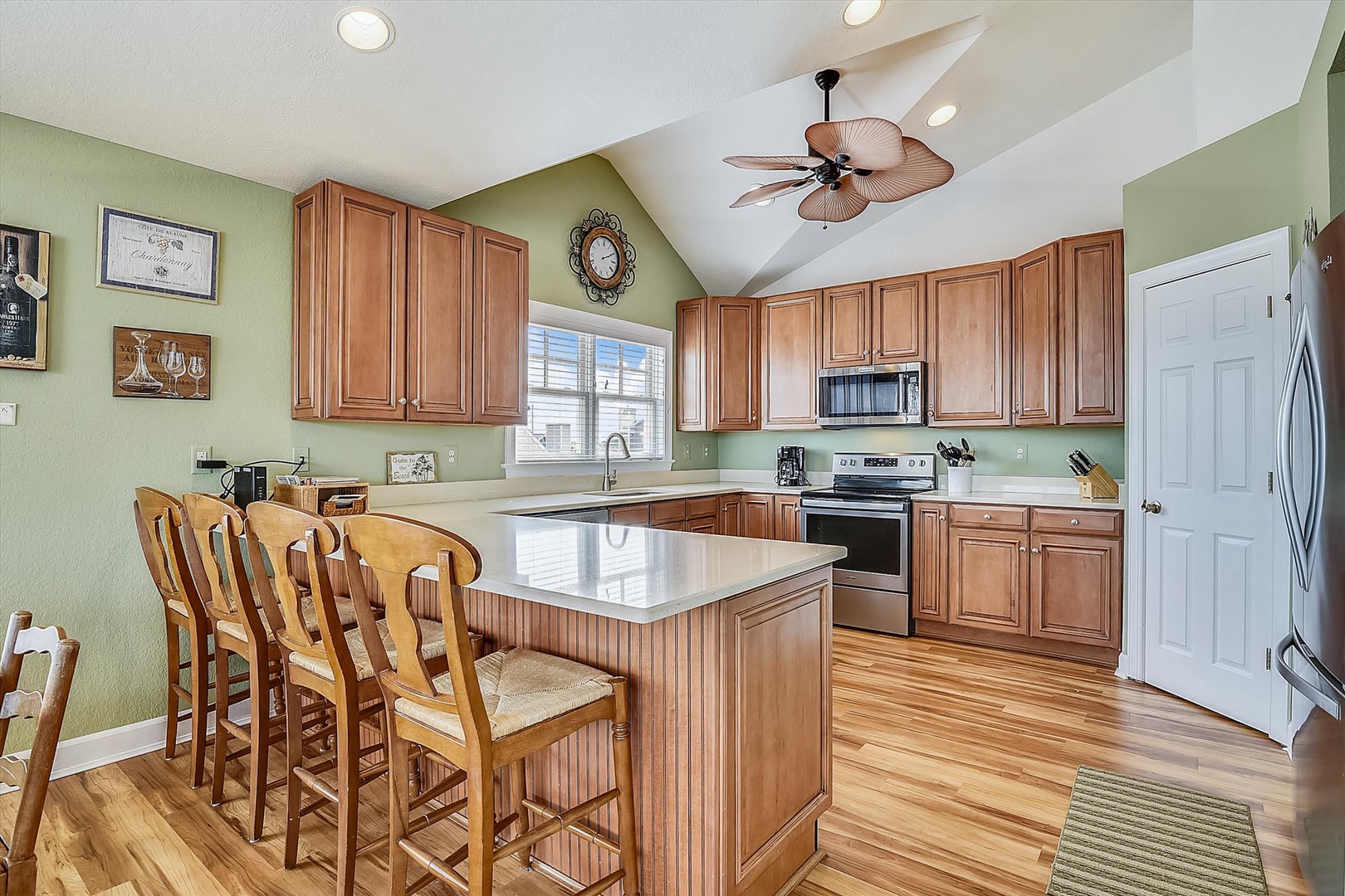 You'll love cooking in this spacious kitchen featuring warm wood cabinets, granite countertops, and a breakfast bar perfect for morning coffee.