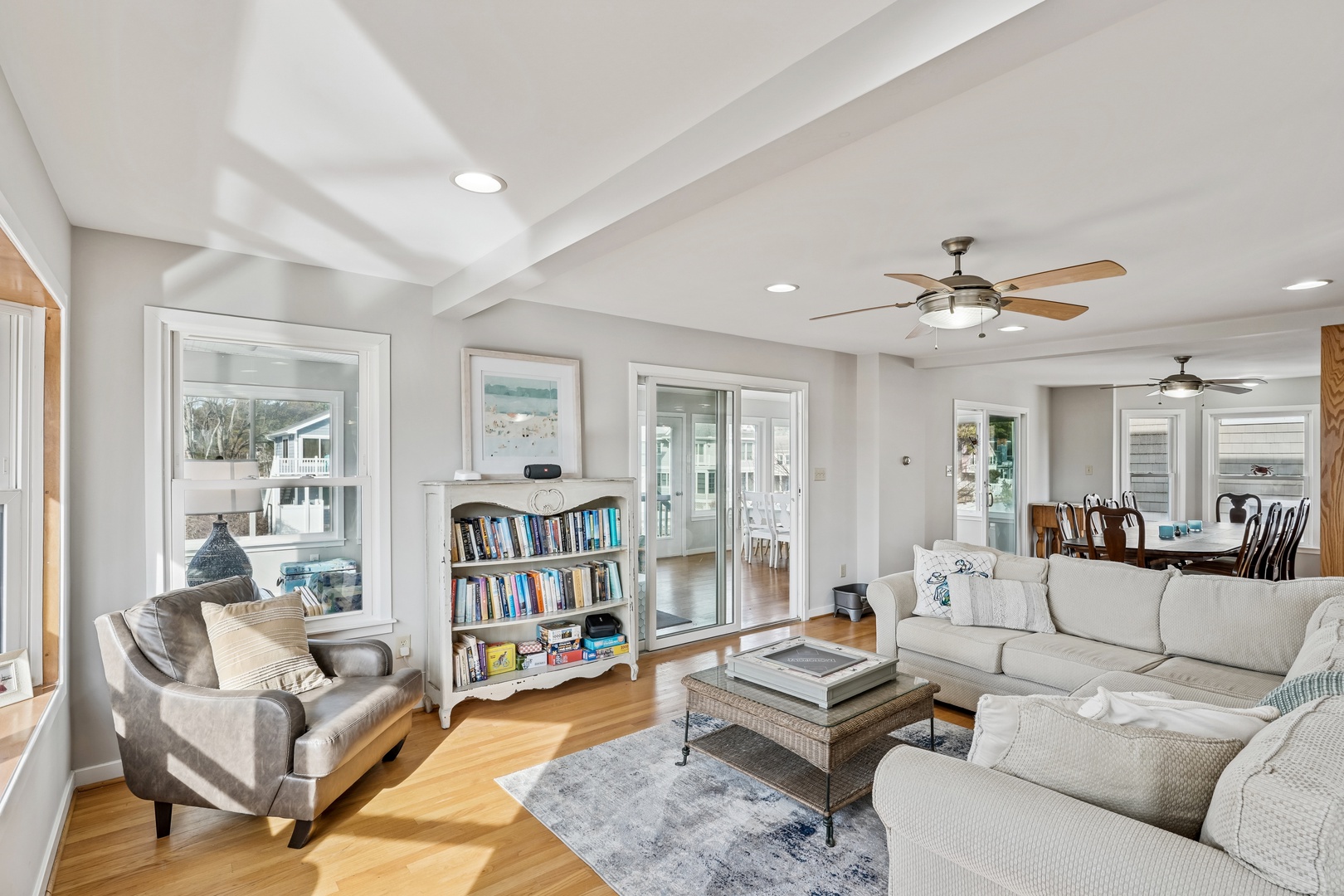 Unwind in your bright, airy living room with coffered ceilings, cozy sectional seating, and thoughtful touches like books for quiet afternoons.
