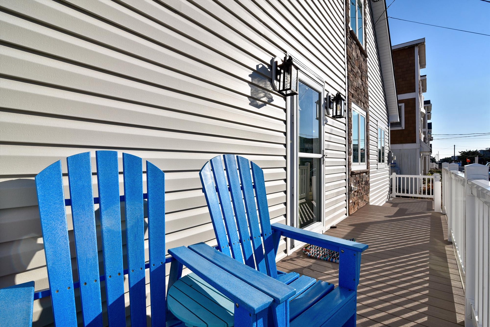 Bright blue Adirondack chairs on a private deck create your perfect spot for morning coffee or sunset relaxation. This inviting outdoor space is all yours.