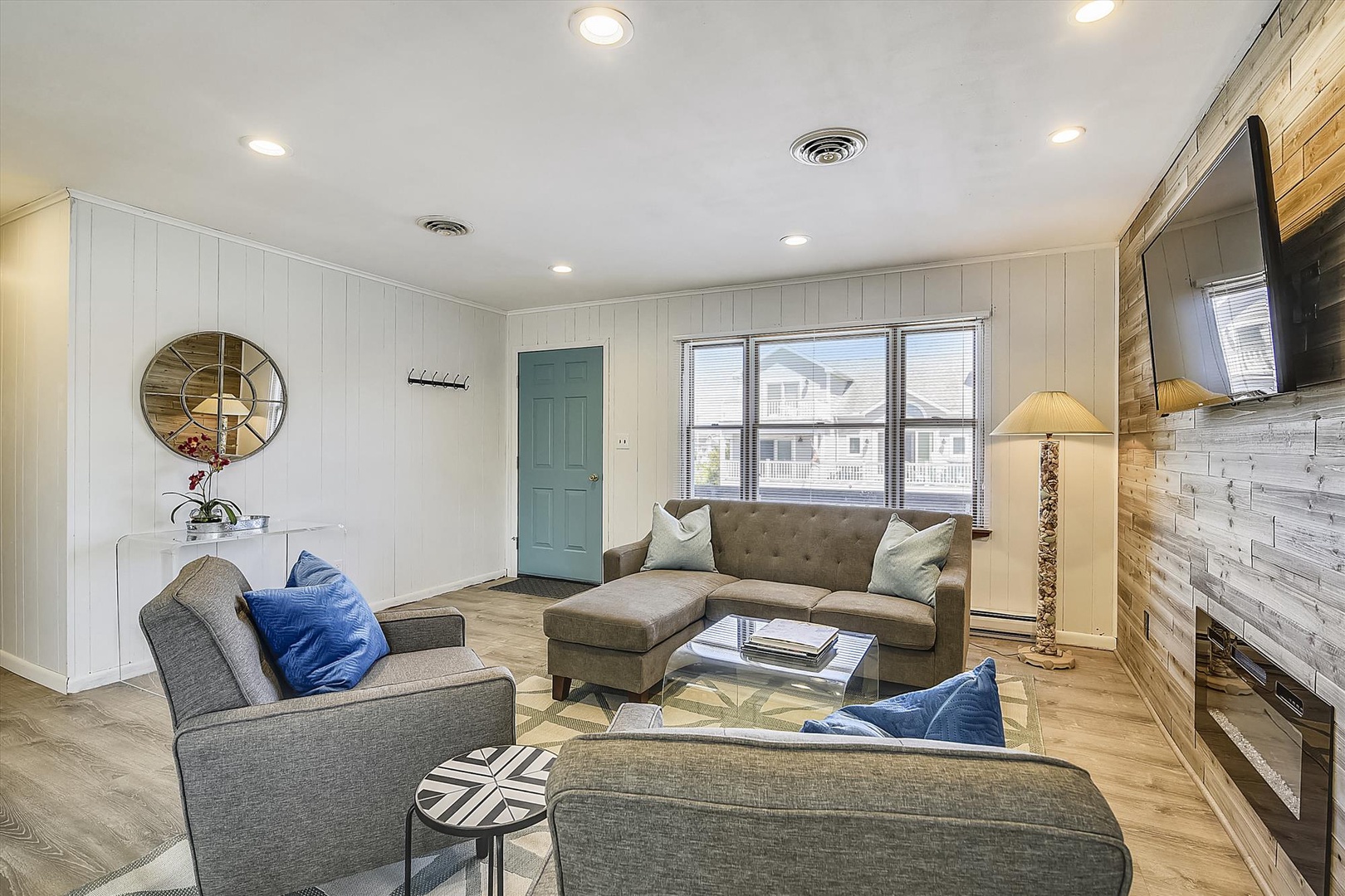 Sink into plush seating and unwind in your bright, modern living space with warm wood accents, coastal decor, and a flat-screen for cozy evenings.