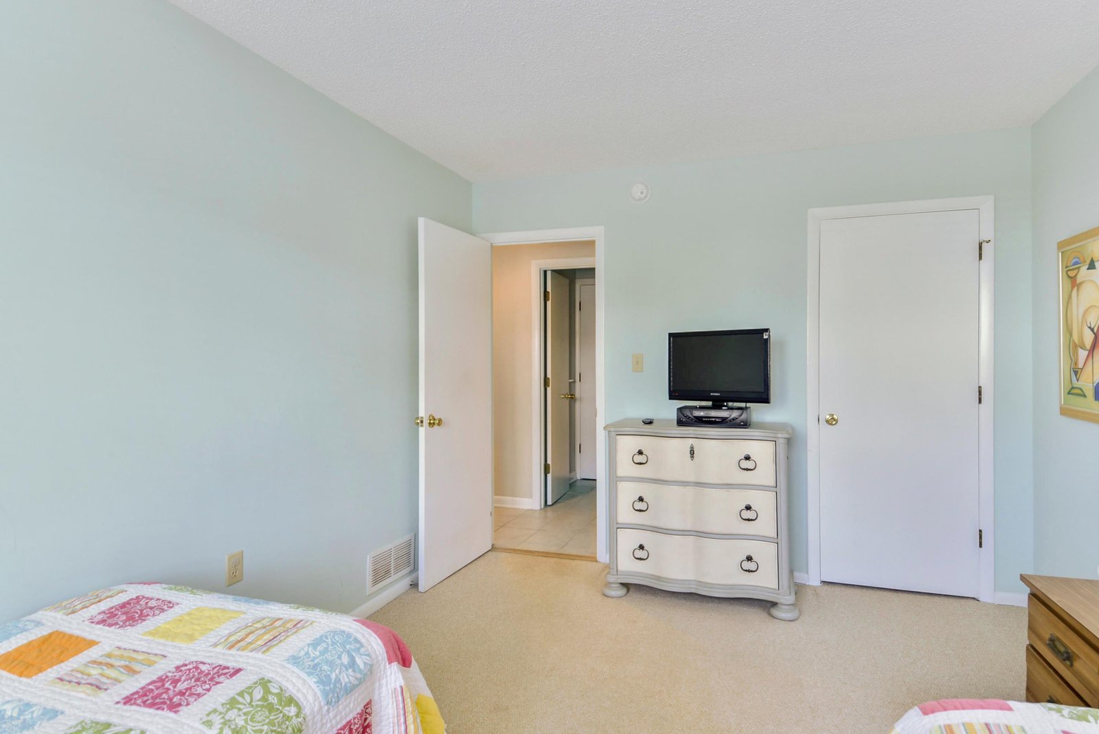 Relax in your peaceful bedroom with soft blue walls, charming vintage-style furnishings, and cozy beds ready for a restful night's sleep.