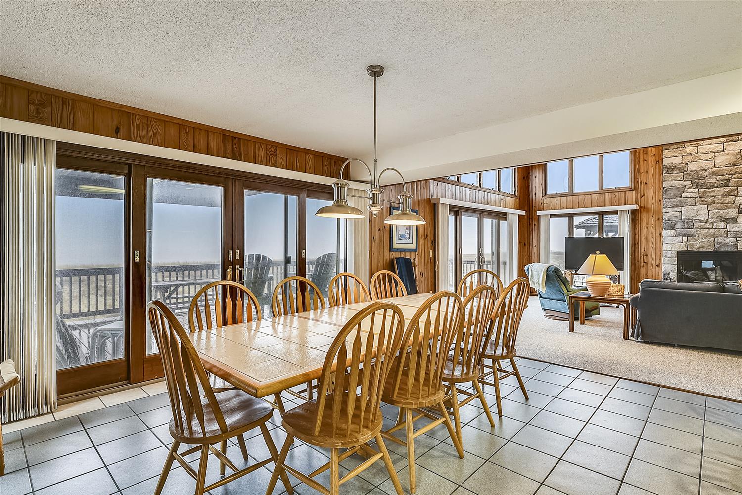 Gather around a spacious table for memorable meals with your group, surrounded by warm wood accents and natural light streaming through expansive windows.