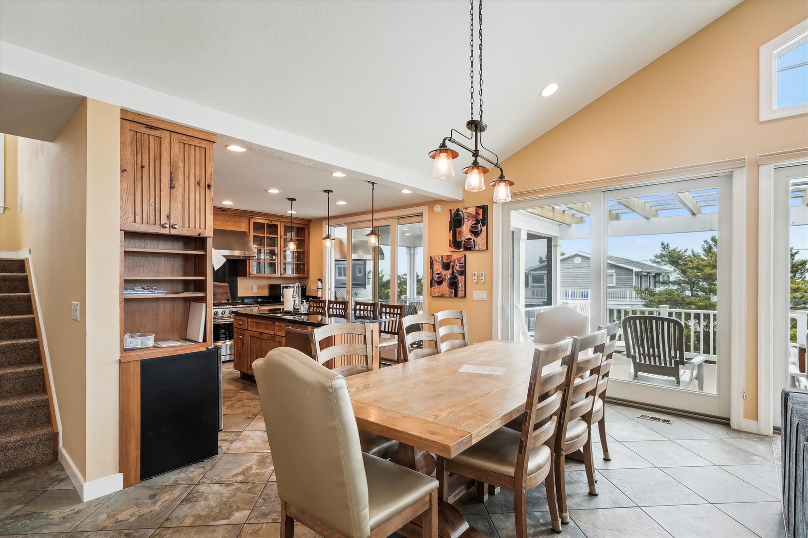 Picture yourself gathered around this handsome wooden table, bathed in natural light from those wide glass doors. Your kitchen opens beautifully to the dining space, making meal prep a social affair, and your private balcony awaits just beyond.
