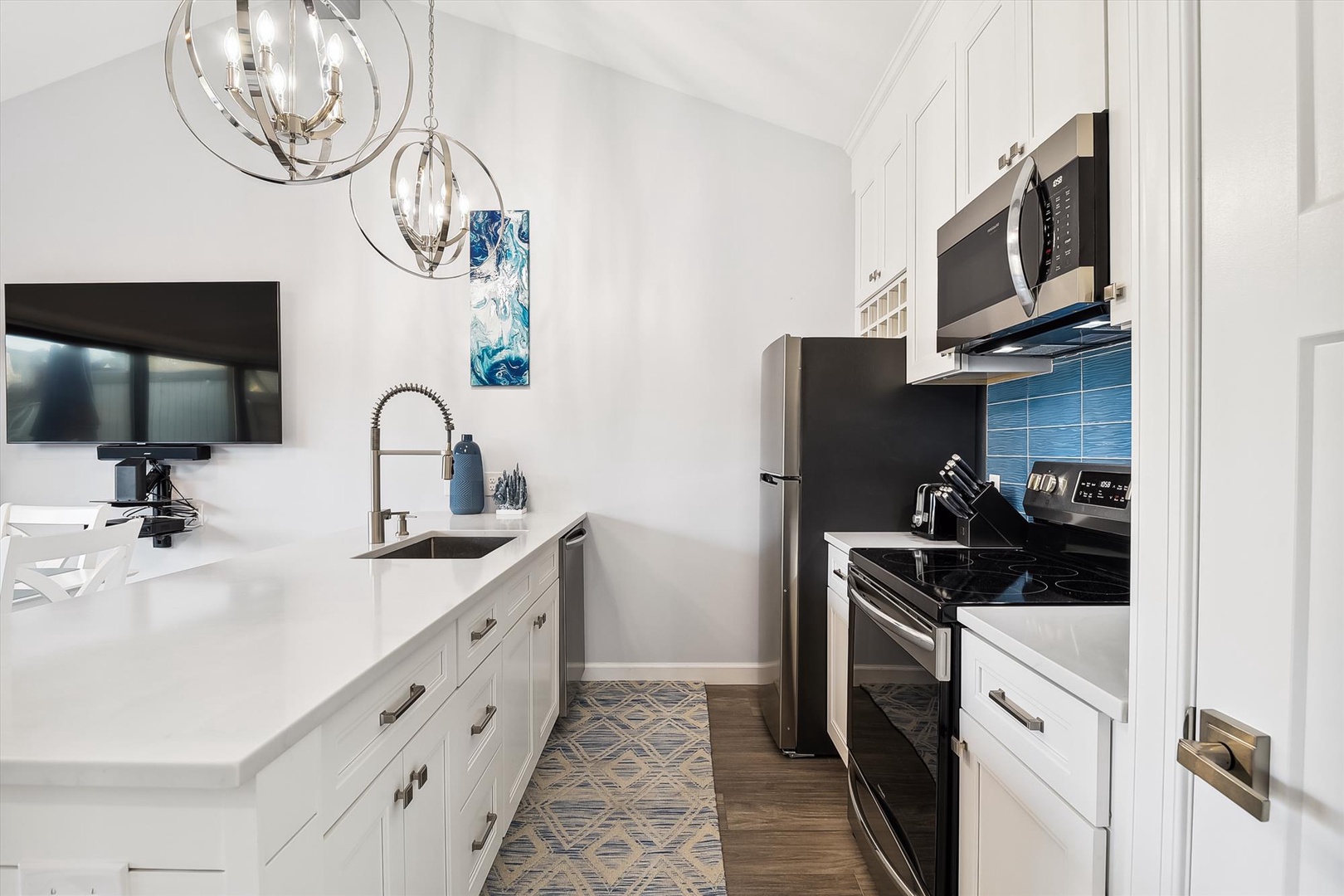 Your bright, fully equipped kitchen features sleek white cabinetry, modern appliances, and chic pendant lighting—perfect for whipping up delicious home-cooked meals during your stay.