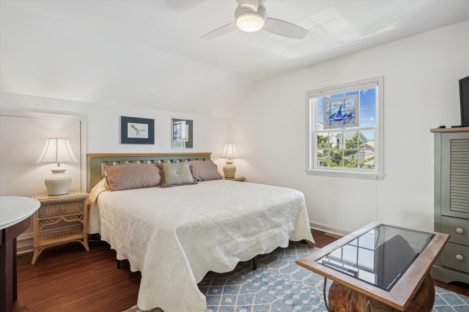 Drift off in this serene bedroom where soft coastal breezes meet stylish comfort. Your plush bed beckons beneath vaulted ceilings while natural light pours through windows framing tranquil neighborhood views.