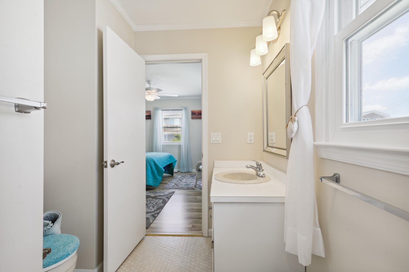 This bright, clean bathroom features a spacious vanity with fresh towels at your fingertips. Natural light flows in through the window, giving you a fresh, relaxing start each morning.