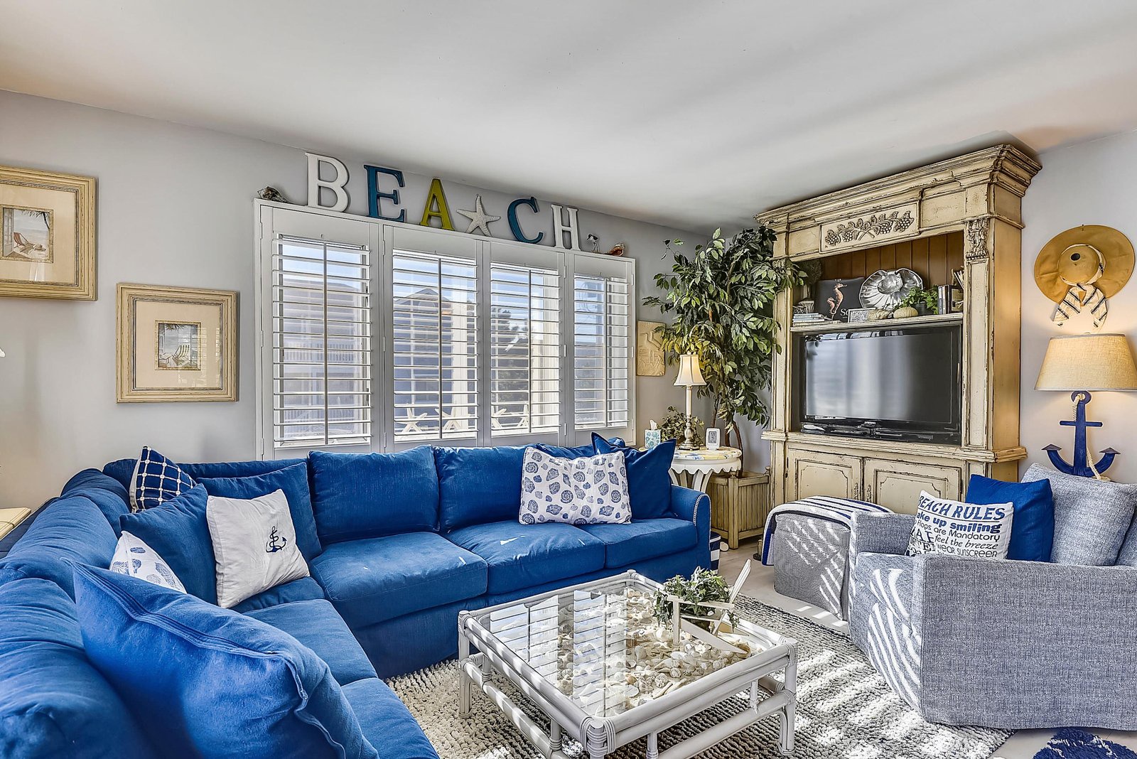 Sink into plush blue sofas and soak up the coastal charm, with plenty of space to gather and nautical touches throughout your living area.