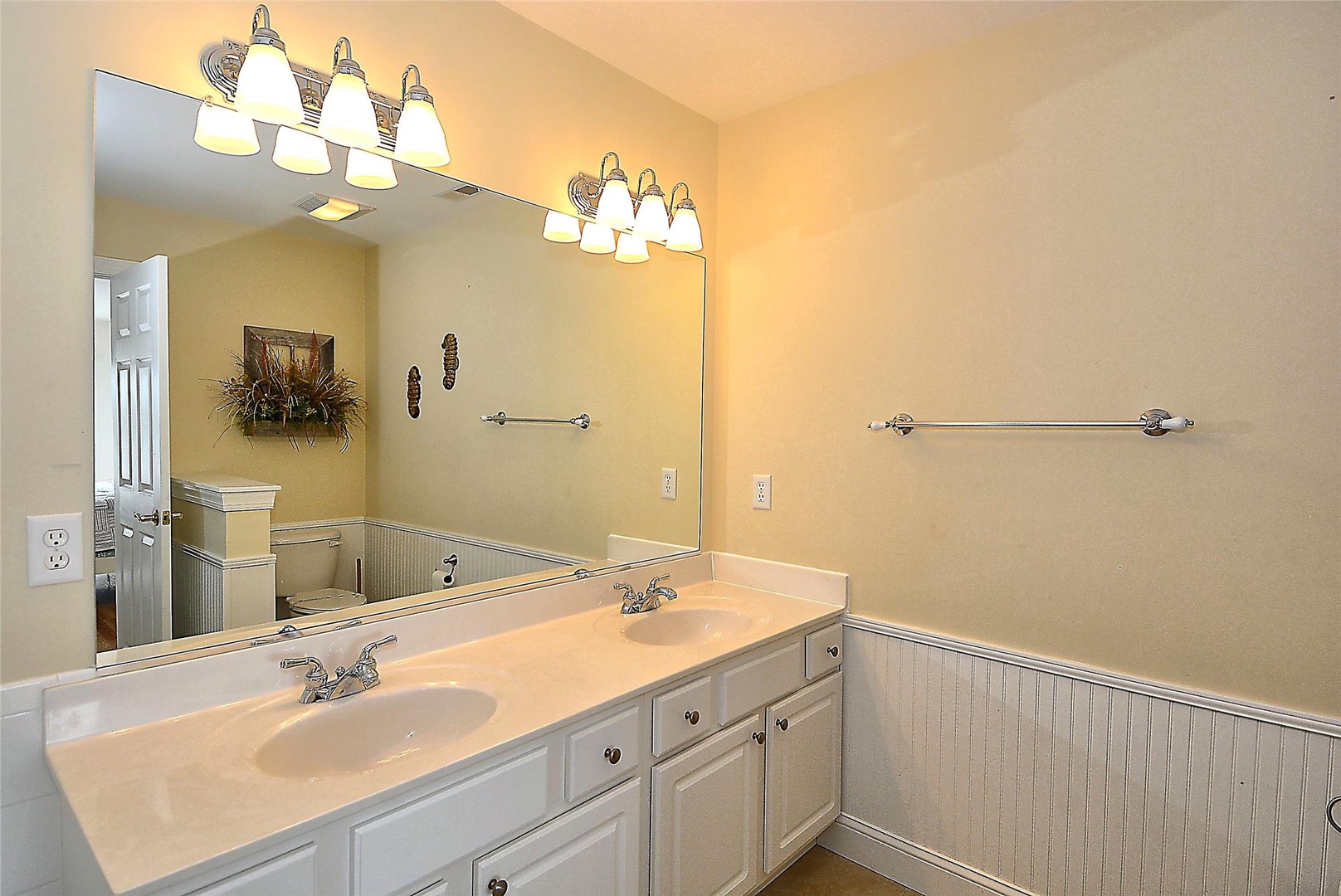 Your spacious dual-sink vanity features warm lighting and generous counter space, perfect for getting ready for a day of coastal adventures.