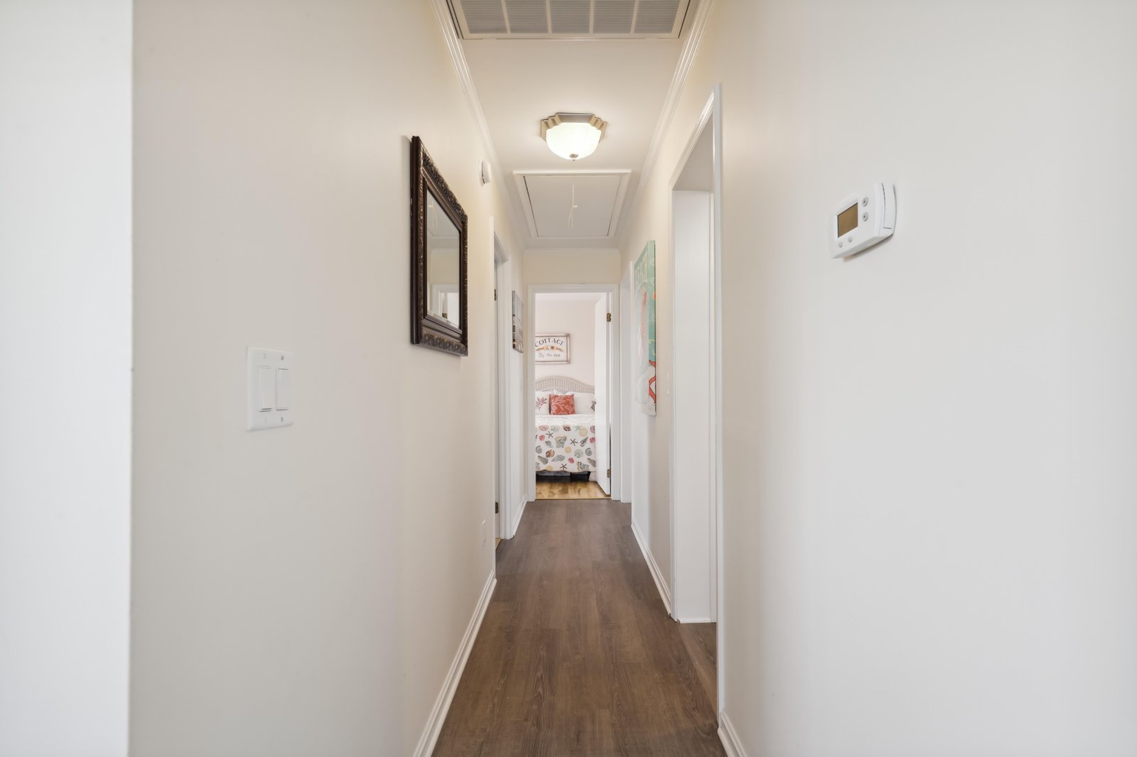 Your private hallway offers seamless flow between bedrooms, with warm wood floors and thoughtful touches like climate control and soft overhead lighting to make every corner feel welcoming.