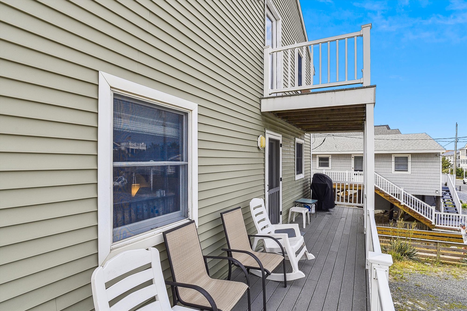 Relax on your private deck with comfortable seating and a gas grill, perfect for morning coffee or evening gatherings under clear blue skies.