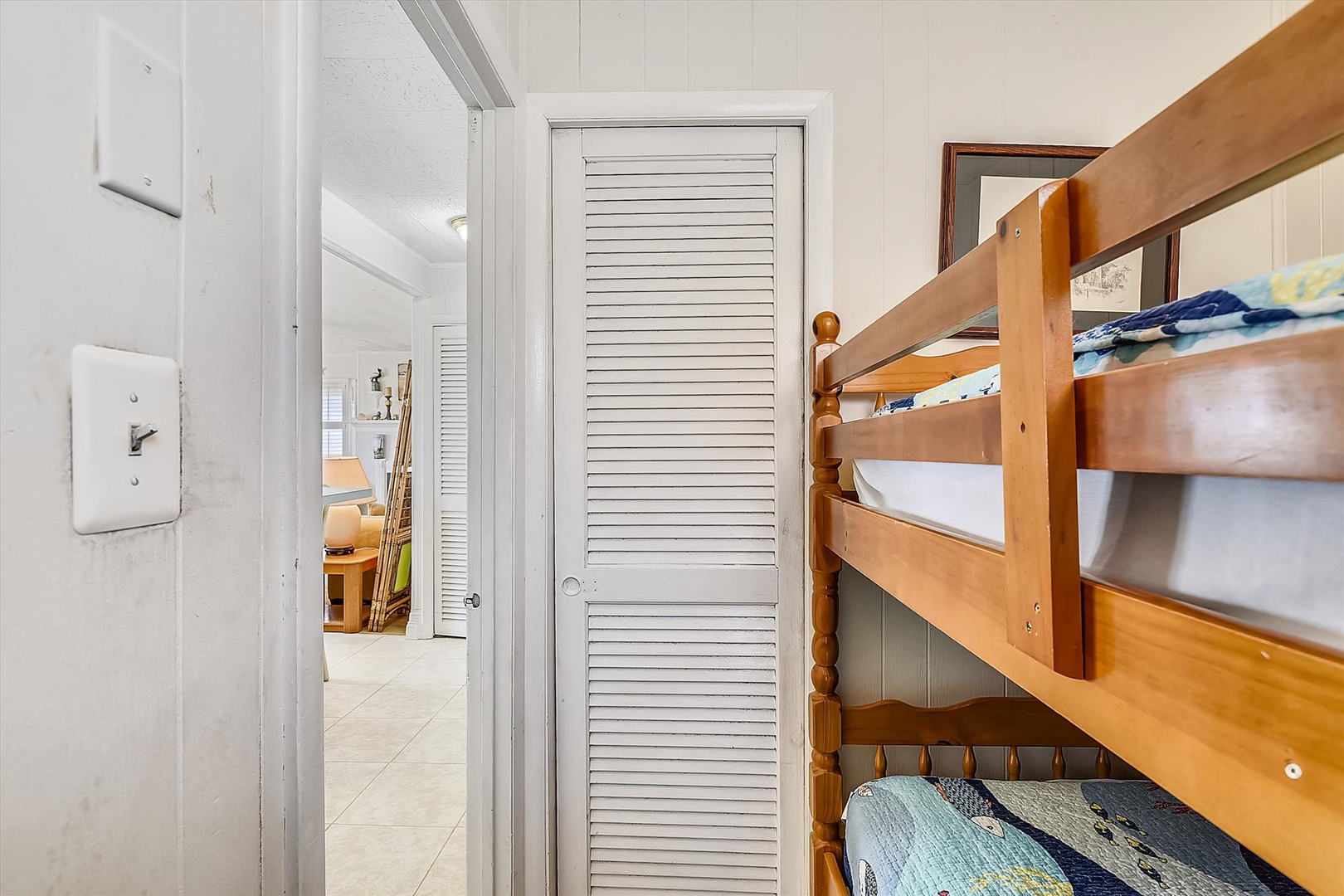 A cozy bunk room with warm wood tones offers flexible sleeping for families or groups, with a clean white palette and easy access to shared spaces.