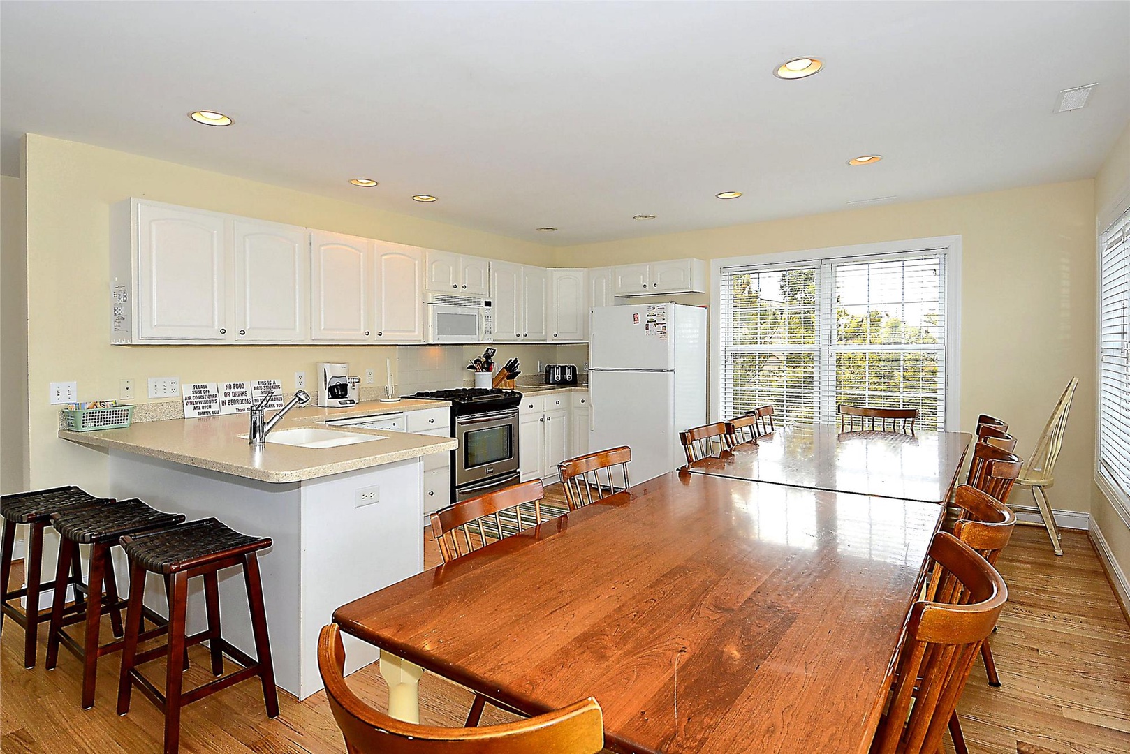 Gather around this spacious kitchen and dining area, where bright natural light and white cabinetry create a welcoming atmosphere for your group meals and conversations.