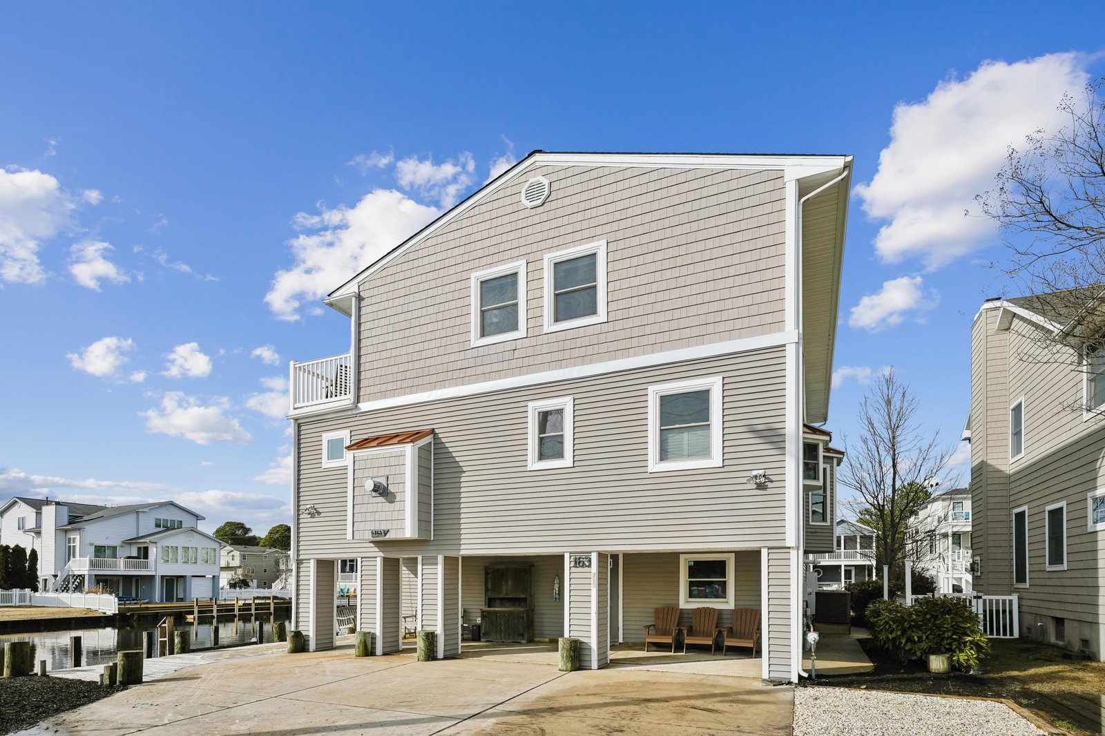 A modern waterfront rental offering comfortable canal-side living with convenient parking and an inviting porch for relaxing outdoors in a peaceful residential setting.