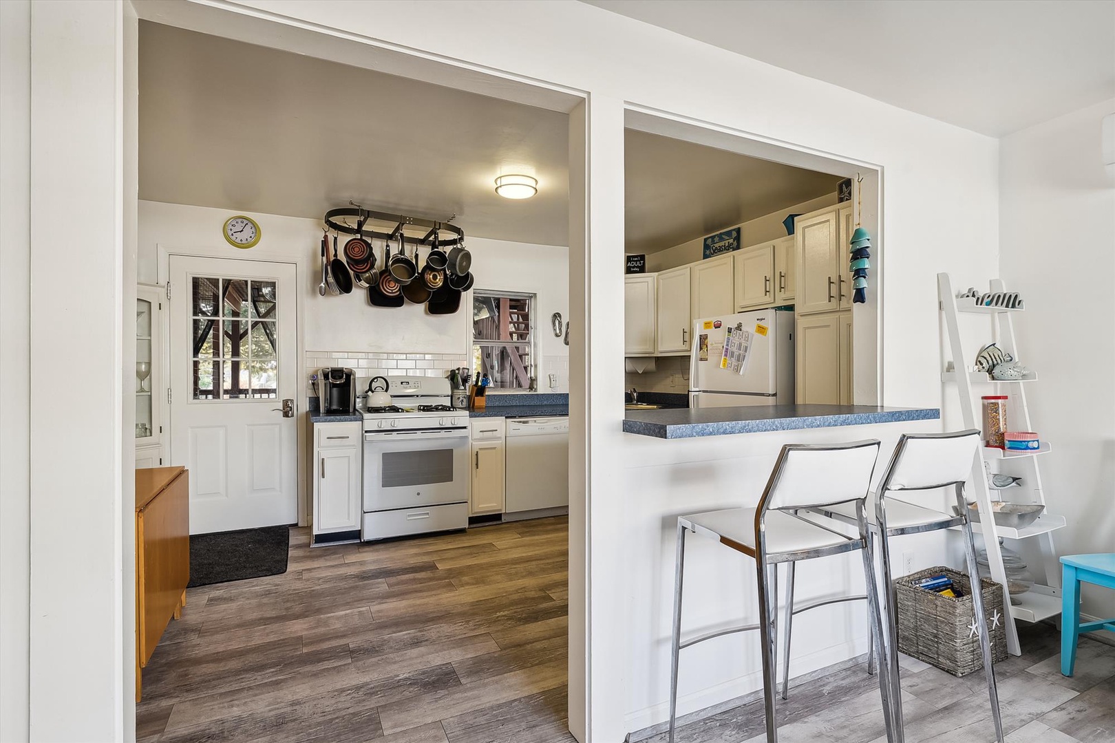 Your fully equipped kitchen features a gas stove, pot rack, and breakfast bar with seating—perfect for whipping up meals and enjoying casual dining together.