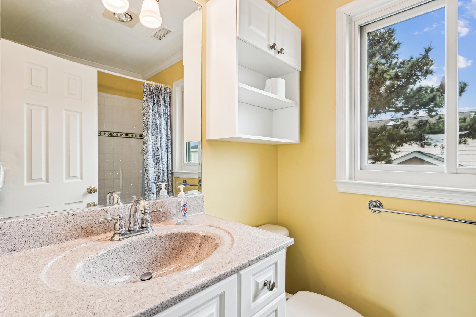 Bright and cheerful bathroom with plenty of storage and natural light to start your day feeling refreshed.
