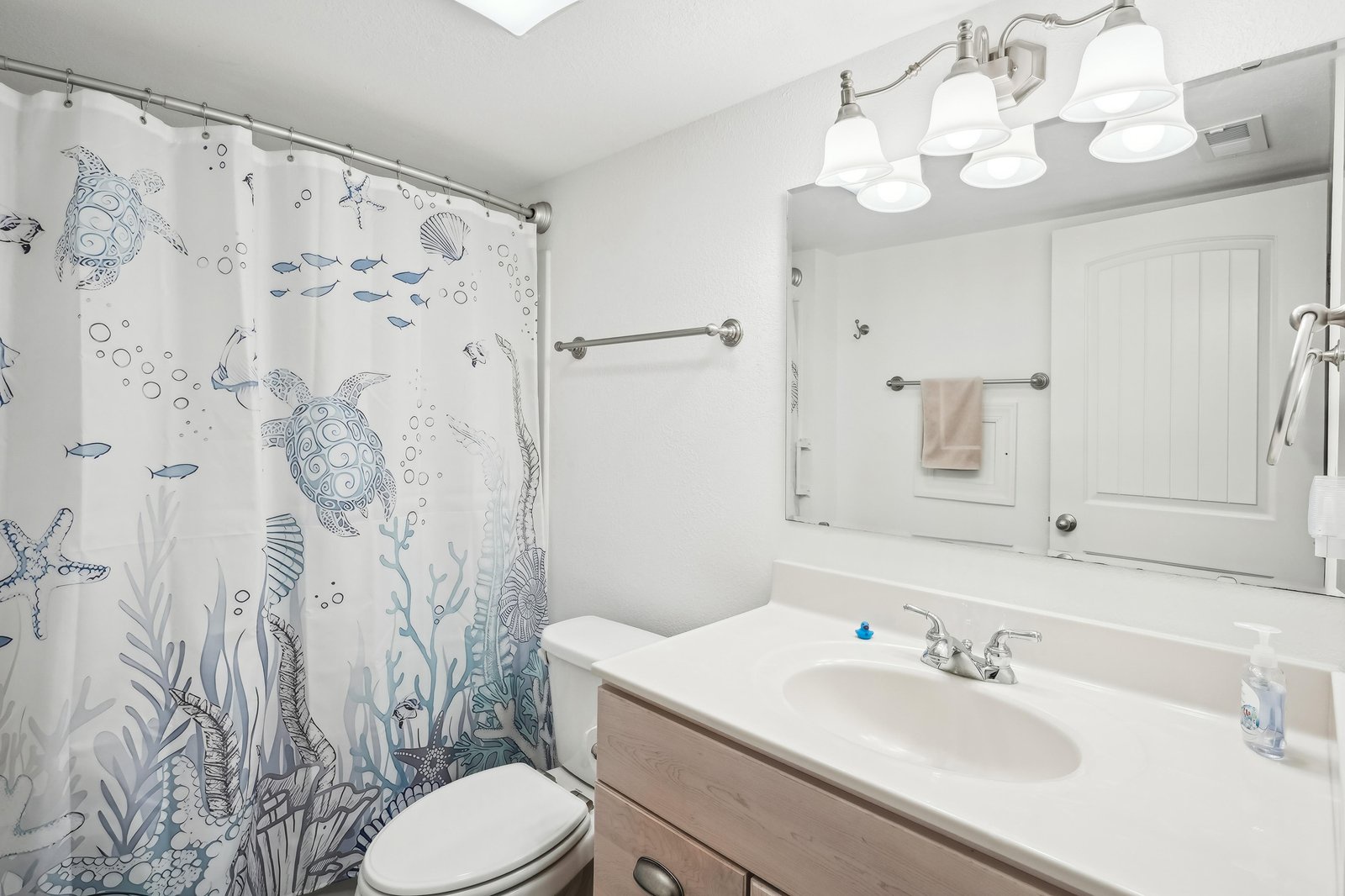 Freshen up in your private bathroom, complete with a charming ocean-themed shower curtain, plenty of counter space, and soft towels waiting for you.