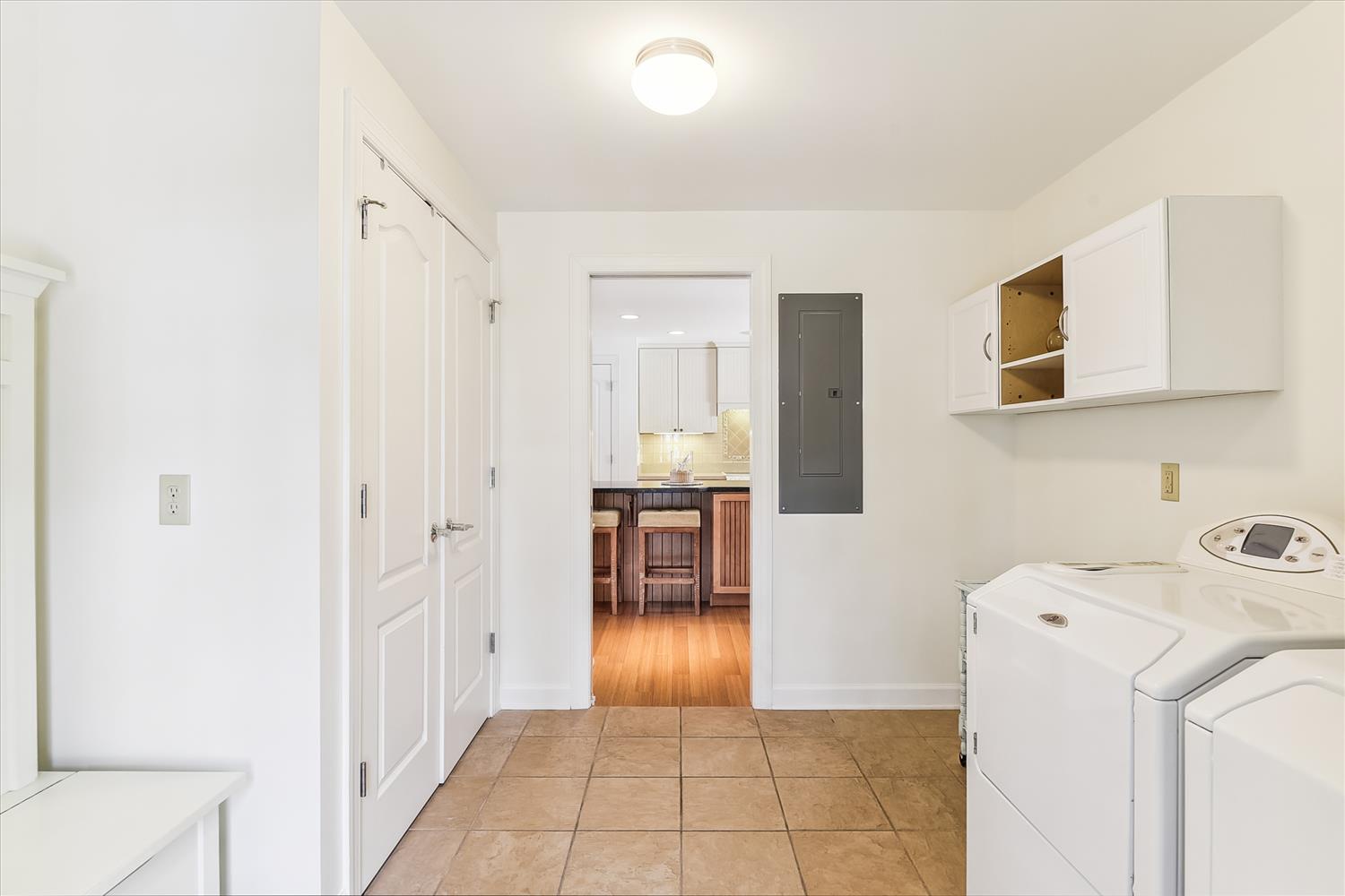 Clean, well-organized laundry room with modern appliances, making it easy for you to keep fresh throughout your stay. Bright tile floors and a convenient hallway connection to the kitchen add to the home's practical comfort.