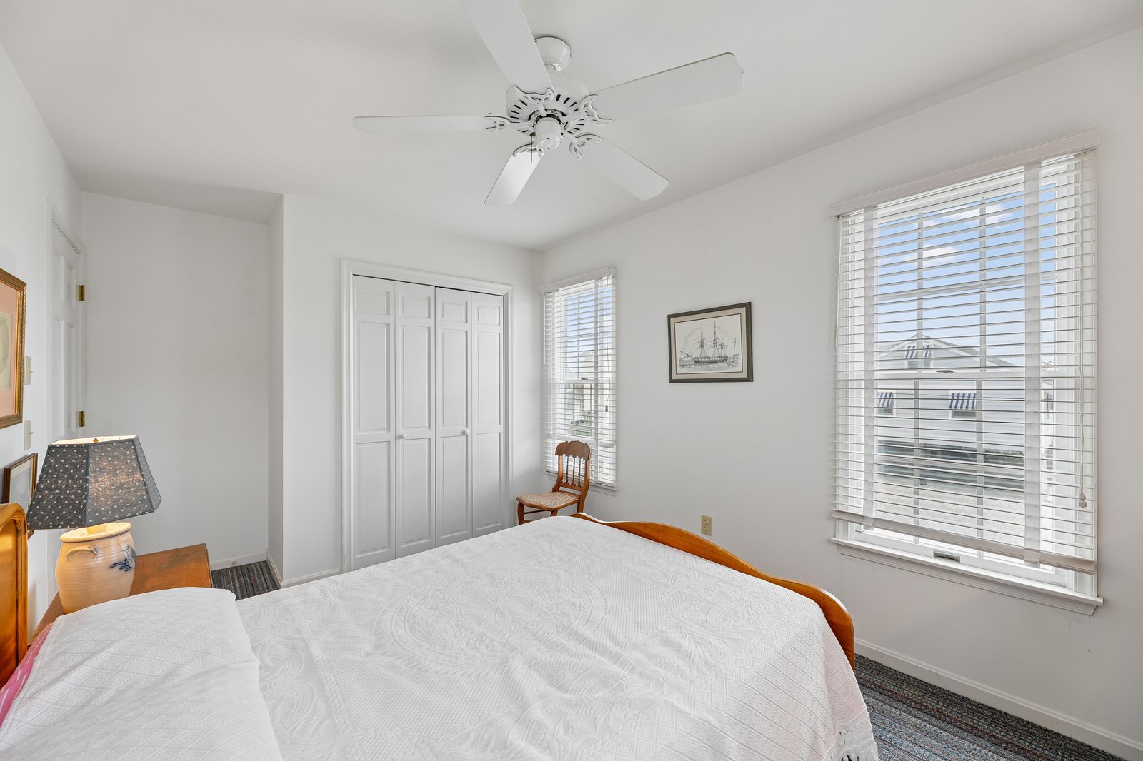 Settle into this serene bedroom where coastal breezes from the ceiling fan and soft natural light create your peaceful retreat by the sea.