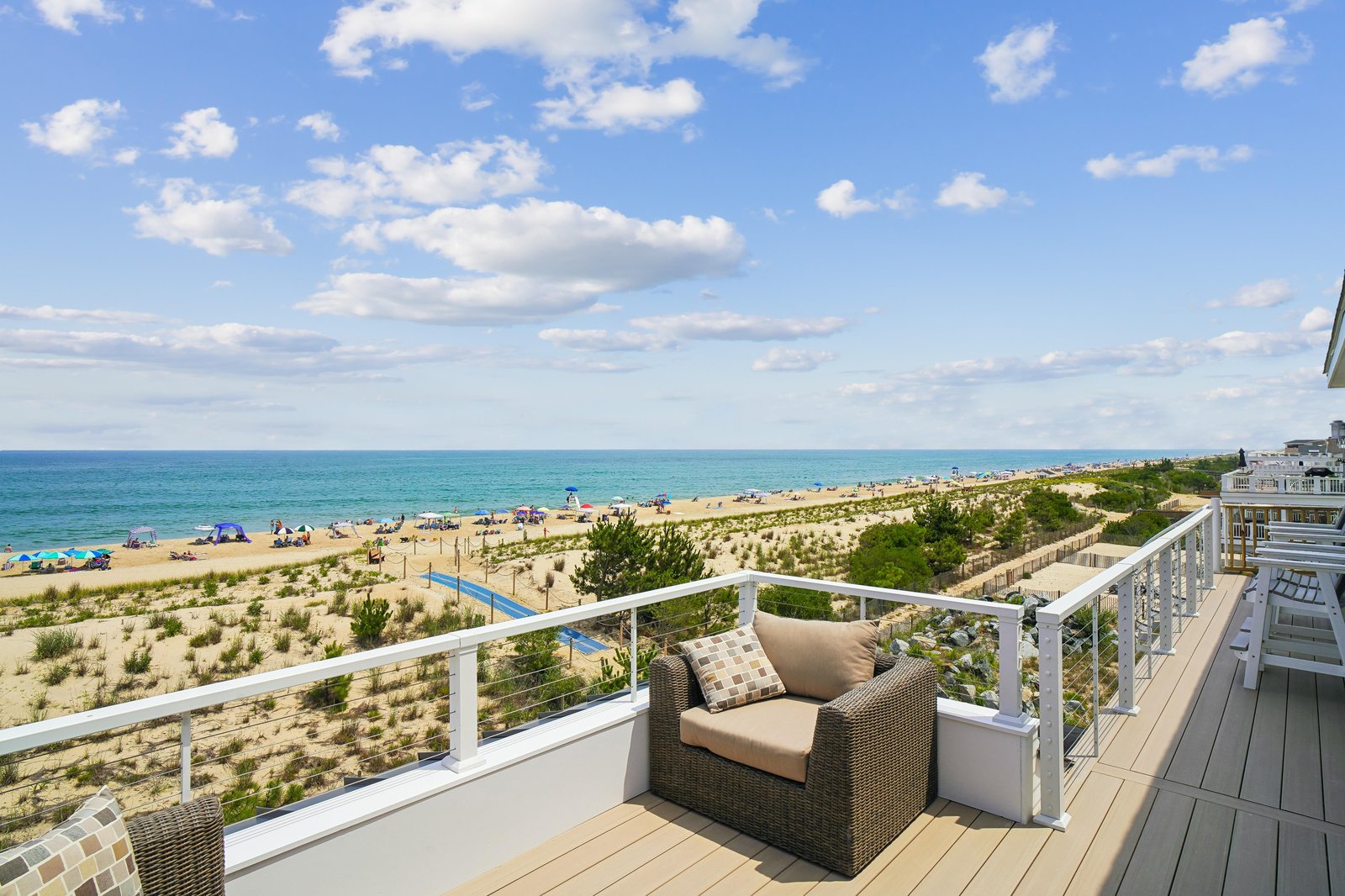 A stunning beachfront view awaits you from this pristine deck, where turquoise waters and soft sands stretch endlessly before you. Settle into comfortable outdoor seating and let the ocean breeze become part of your daily rhythm.