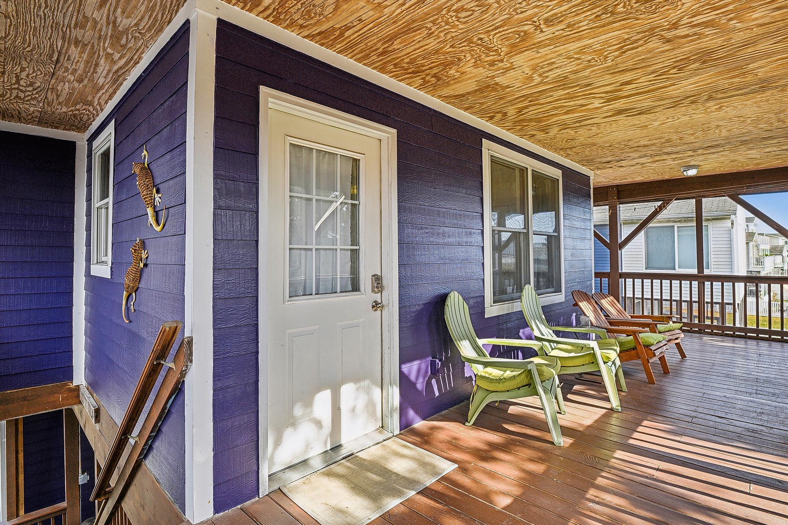 Relax on your private covered deck with colorful Adirondack chairs, shaded by a warm wood ceiling—your personal outdoor retreat for morning coffee or evening conversation.