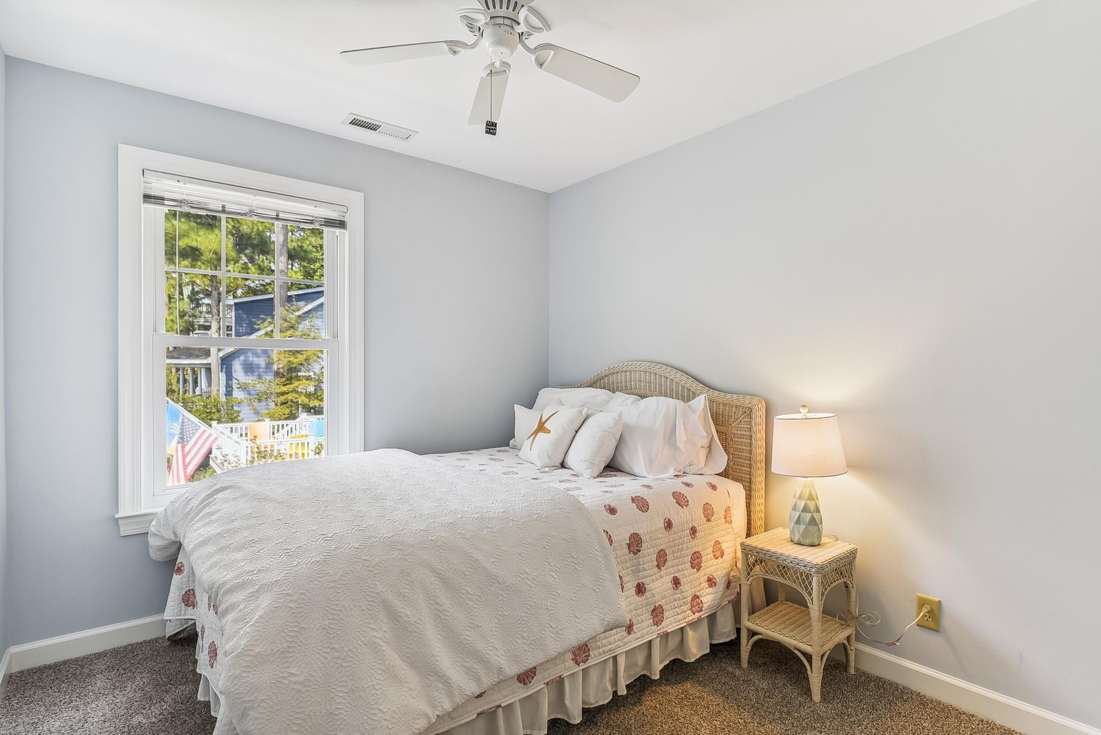 Sink into the plush bedding in your peaceful retreat, where soft coastal light filters through the window and a gentle ceiling fan stirs the air to keep you comfortable.