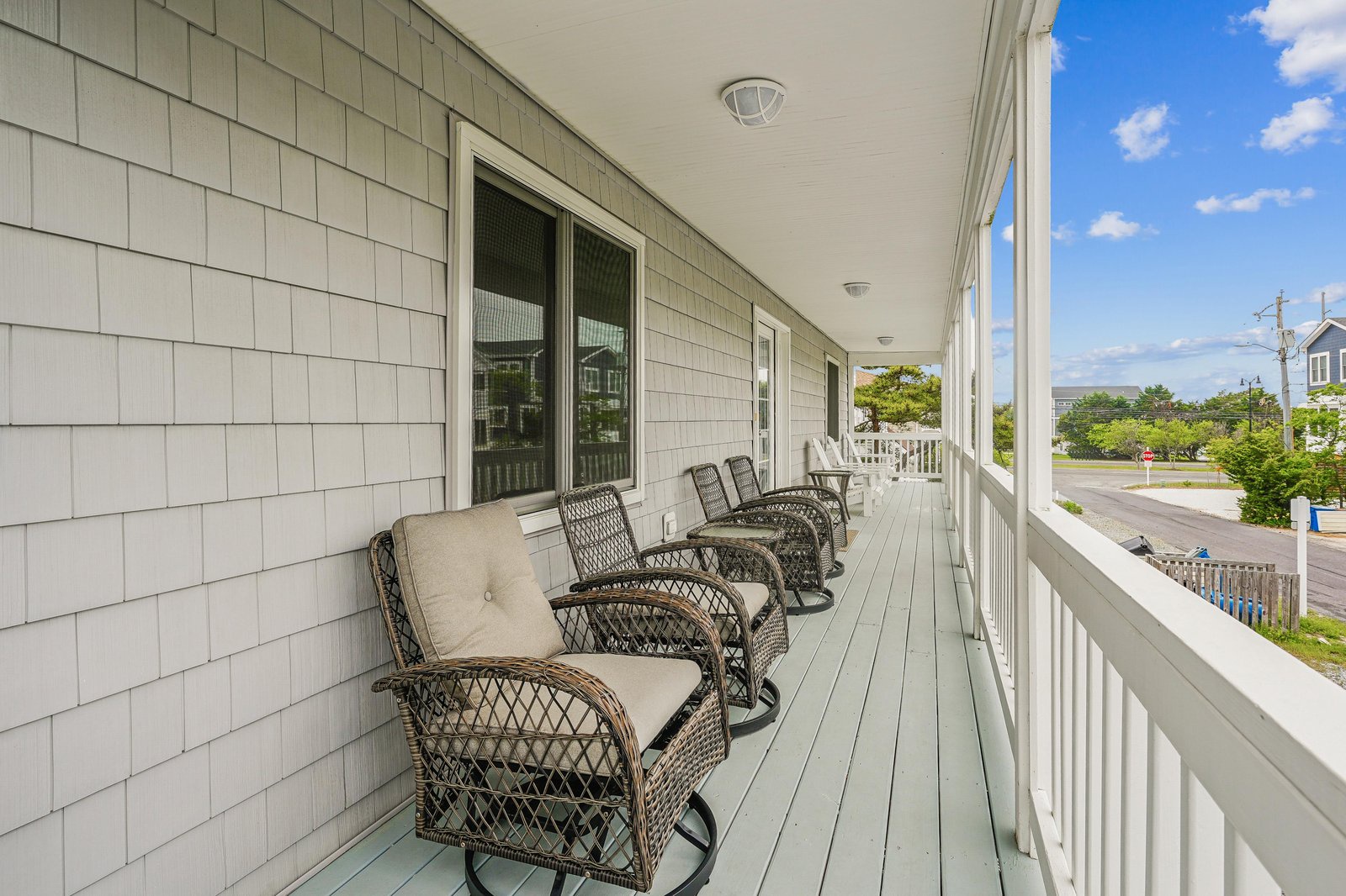 Settle into a row of cushioned porch chairs and let the ocean breeze sweep over you as you watch the neighborhood come to life beneath bright coastal skies.