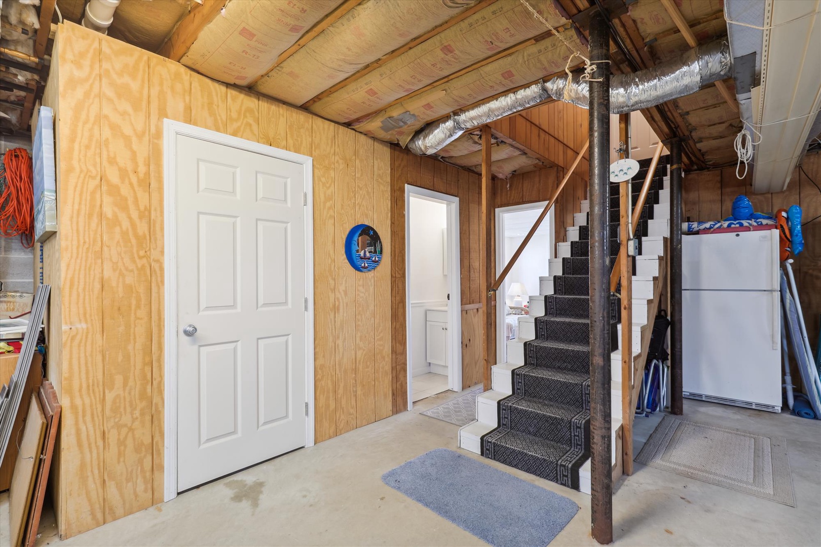 Private entrance with interior staircase connecting living levels. Exposed beam construction creates an open, airy feel throughout the space.