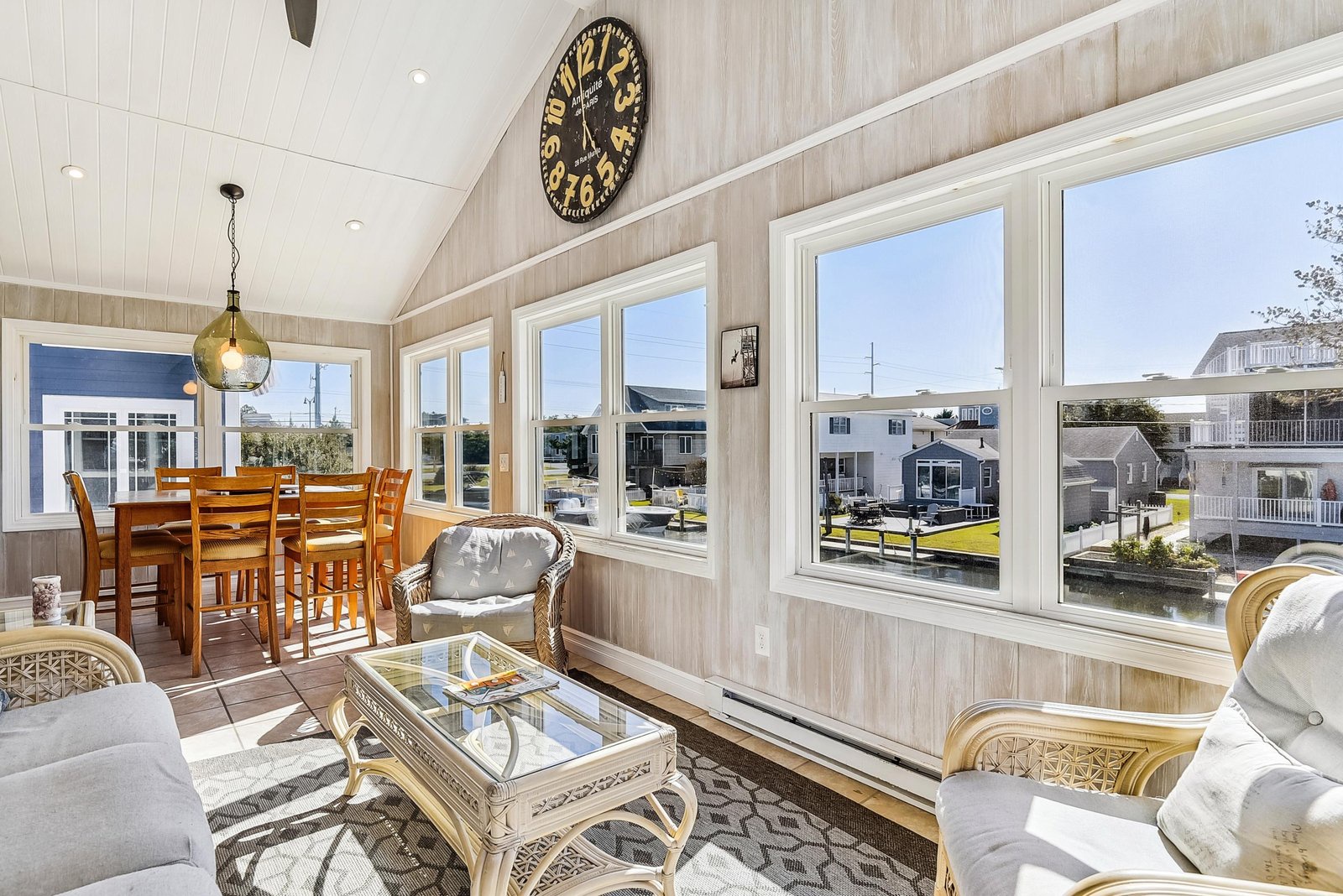 Bright, sunlit living space with vaulted ceilings and expansive windows overlooking the canal. Relax on cozy seating, enjoy casual meals, and embrace the cheerful, airy atmosphere.