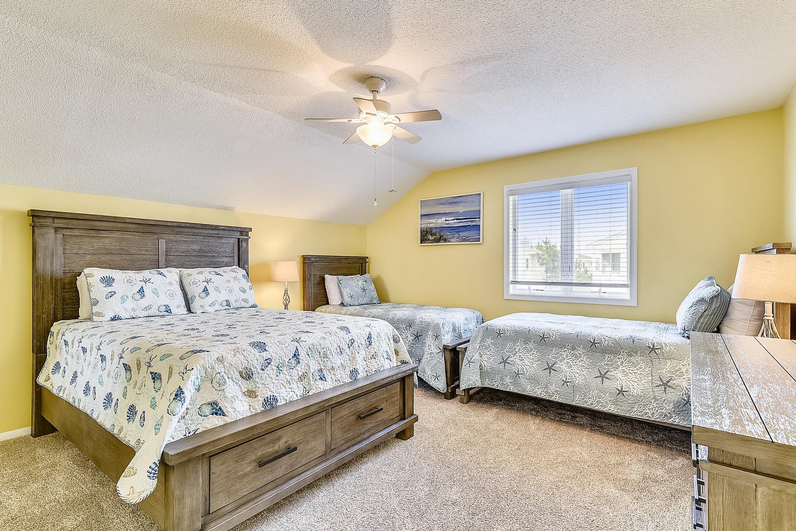 Settle in for the night under cheerful yellow walls and ocean-themed linens. Your cozy multi-bed retreat offers restful sleep for the whole family or group.