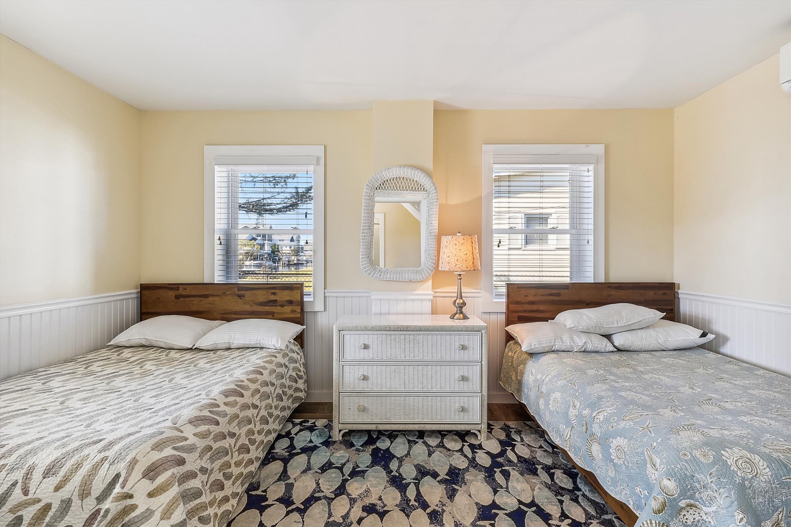 Settle into coastal comfort in this cheerful twin bedroom, where soft yellow walls and gentle morning light invite peaceful rest between your beach adventures.