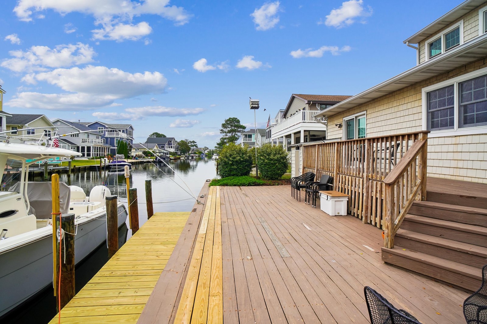 This waterfront property offers private dock access along a peaceful canal, with neighboring homes creating a charming coastal community setting under open skies.