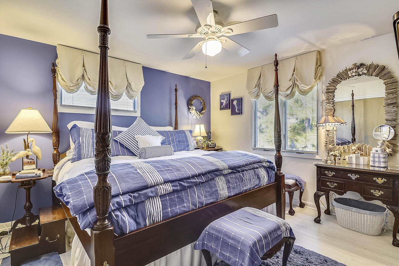 Sink into the plush four-poster bed surrounded by calming blue tones, elegant furnishings, and gentle light from your windows—your serene retreat awaits.
