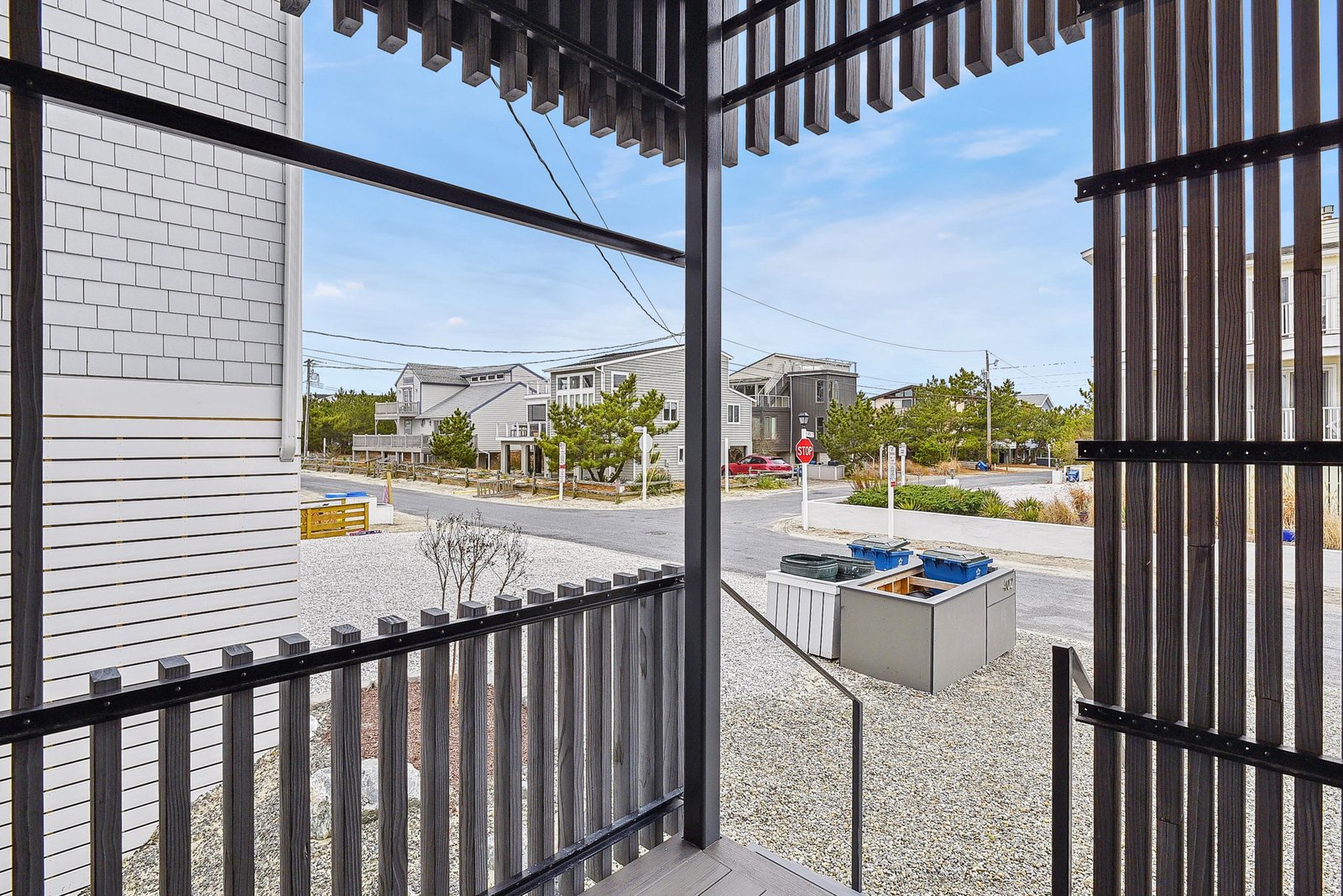 A covered balcony offers views of the quiet residential street and surrounding neighborhood, providing a peaceful spot to enjoy the coastal setting.