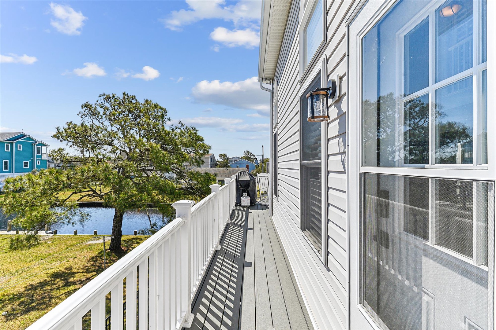 A sun-drenched balcony with blue water and coastal views, offering a serene escape to unwind and breathe in the fresh air.