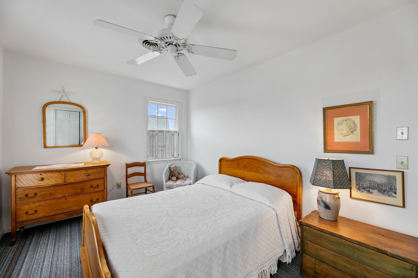 Settle into this cozy bedroom, where soft linens, charming vintage touches, and a gentle ceiling fan create your peaceful retreat after a day of exploring.