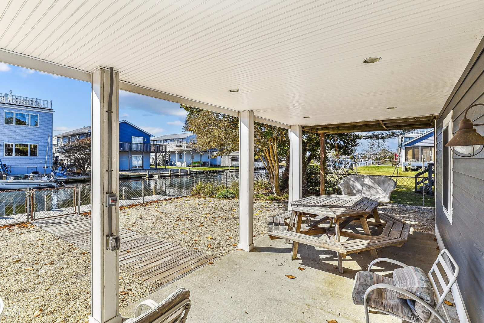 Covered patio with views of the peaceful waterfront canal and neighborhood, perfect for morning coffee or evening gatherings.