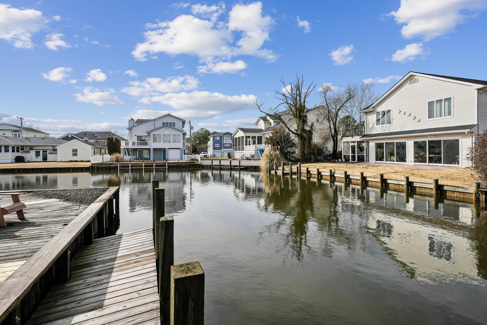 Waterfront neighborhood with canal access, private docks, and a quiet residential setting along calm waters beneath open skies.