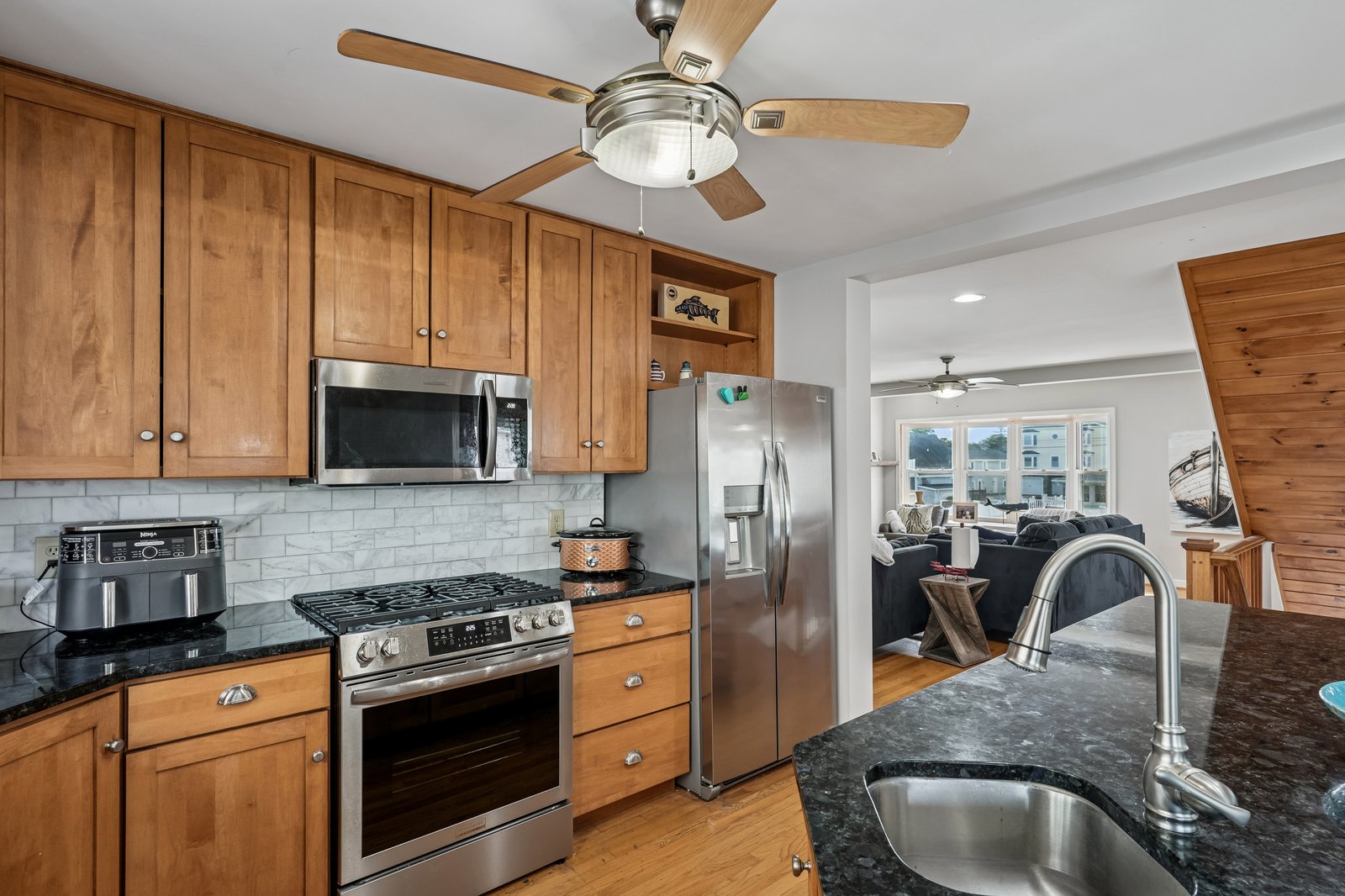 Your fully equipped kitchen features warm wood cabinets, granite counters, and stainless steel appliances, perfect for preparing meals during your stay.