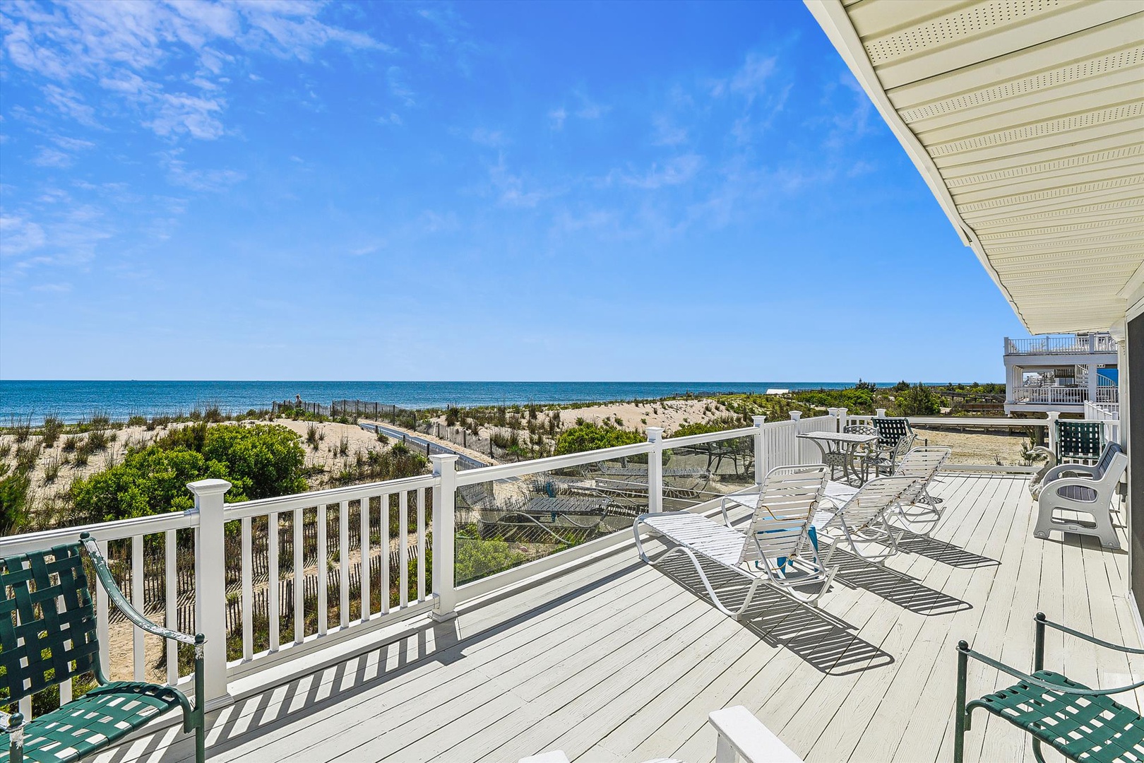Beachfront property features a spacious deck with direct dune access and sweeping ocean views across pristine sandy shores.