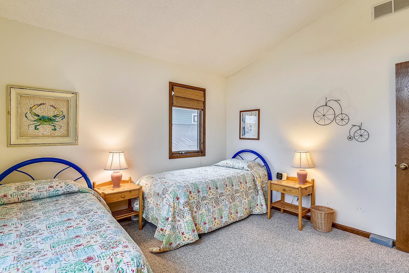 Your bright, cheerful bedroom welcomes you with twin beds dressed in charming quilts, warm bedside lighting, and playful coastal-themed touches that invite sweet dreams by the shore.