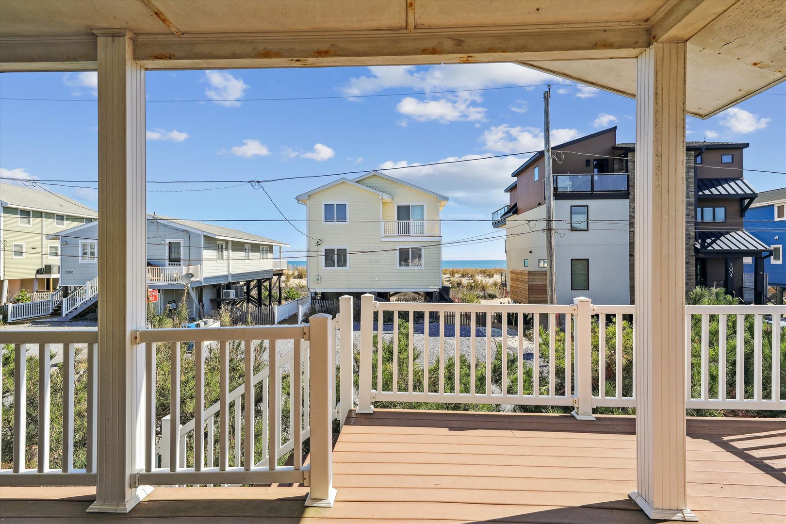 Covered deck overlooking a coastal neighborhood with ocean views, situated in a quiet beach community near the shore.