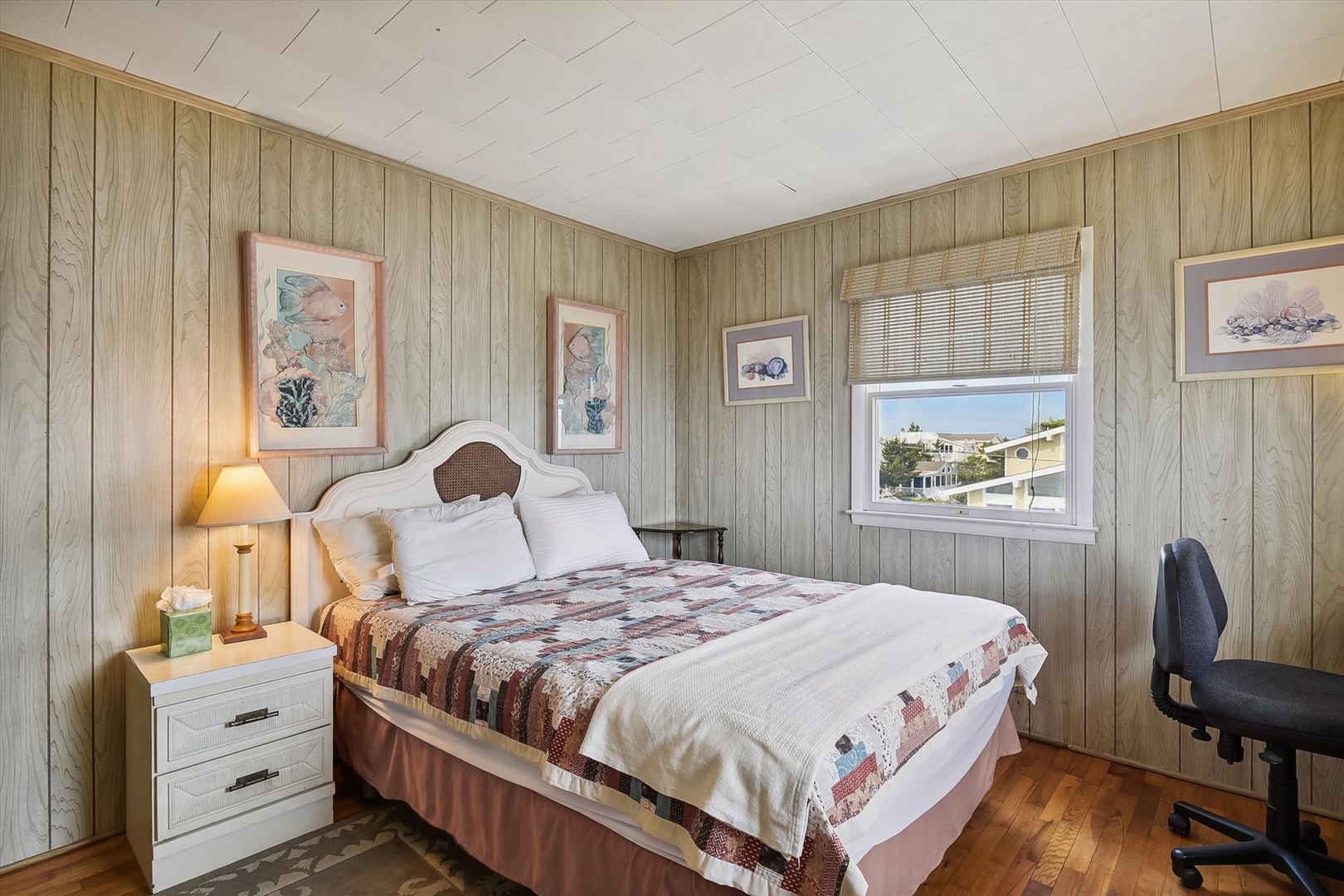 Sink into crisp linens and a cozy quilt in your inviting bedroom. Soft paneled walls, warm hardwood floors, and gentle sunlight create a peaceful retreat after a day of adventure.