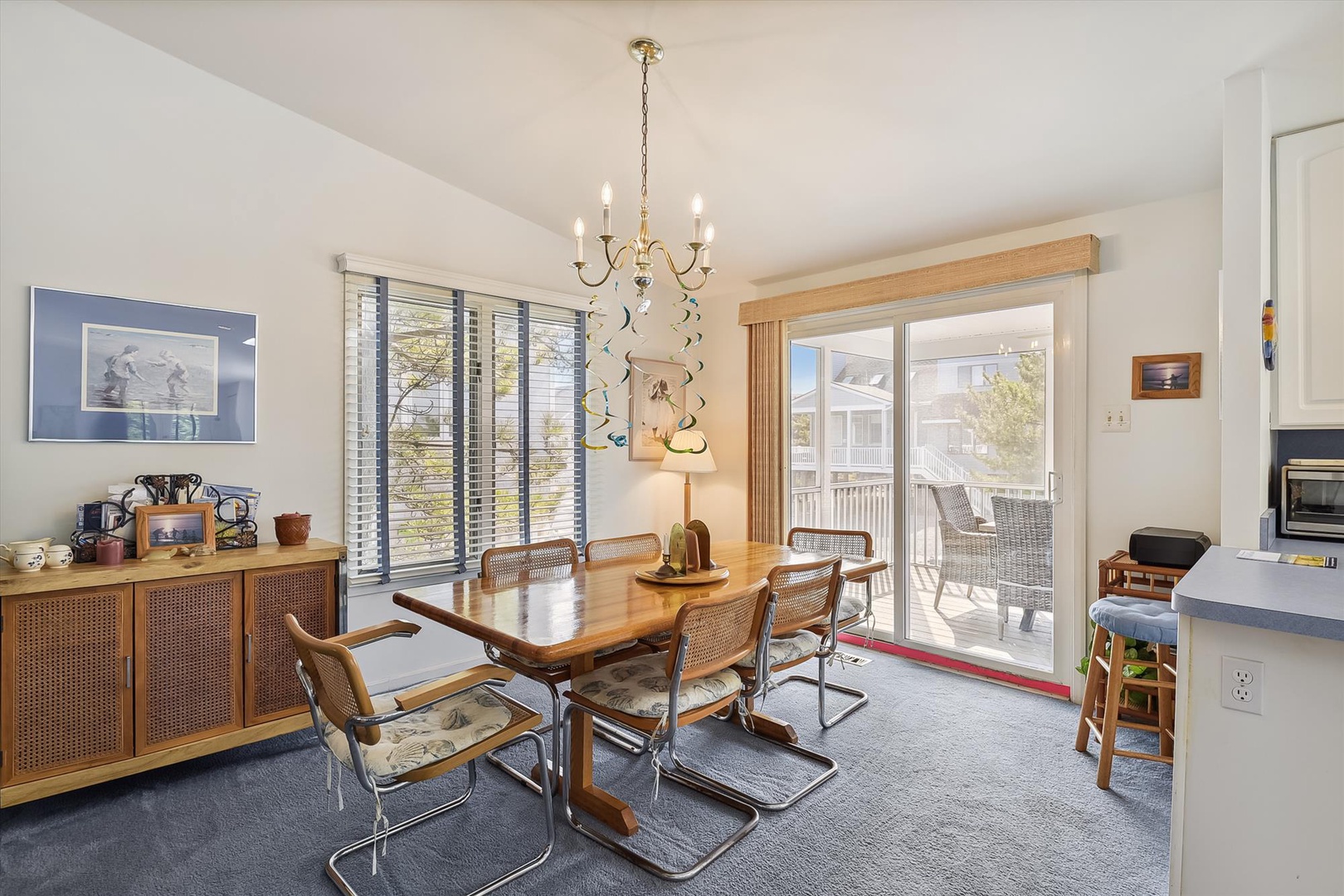 Picture your group gathered around this inviting dining table, sharing meals under the warm chandelier glow. Natural light floods through large windows, and doors open to your private balcony for morning coffee or evening drinks.