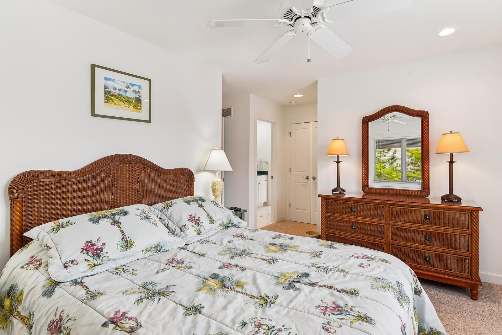 Slip into your peaceful coastal retreat with breezy tropical bedding, wicker furnishings, and soft lamplight welcoming you home after a day of exploring nearby beaches.